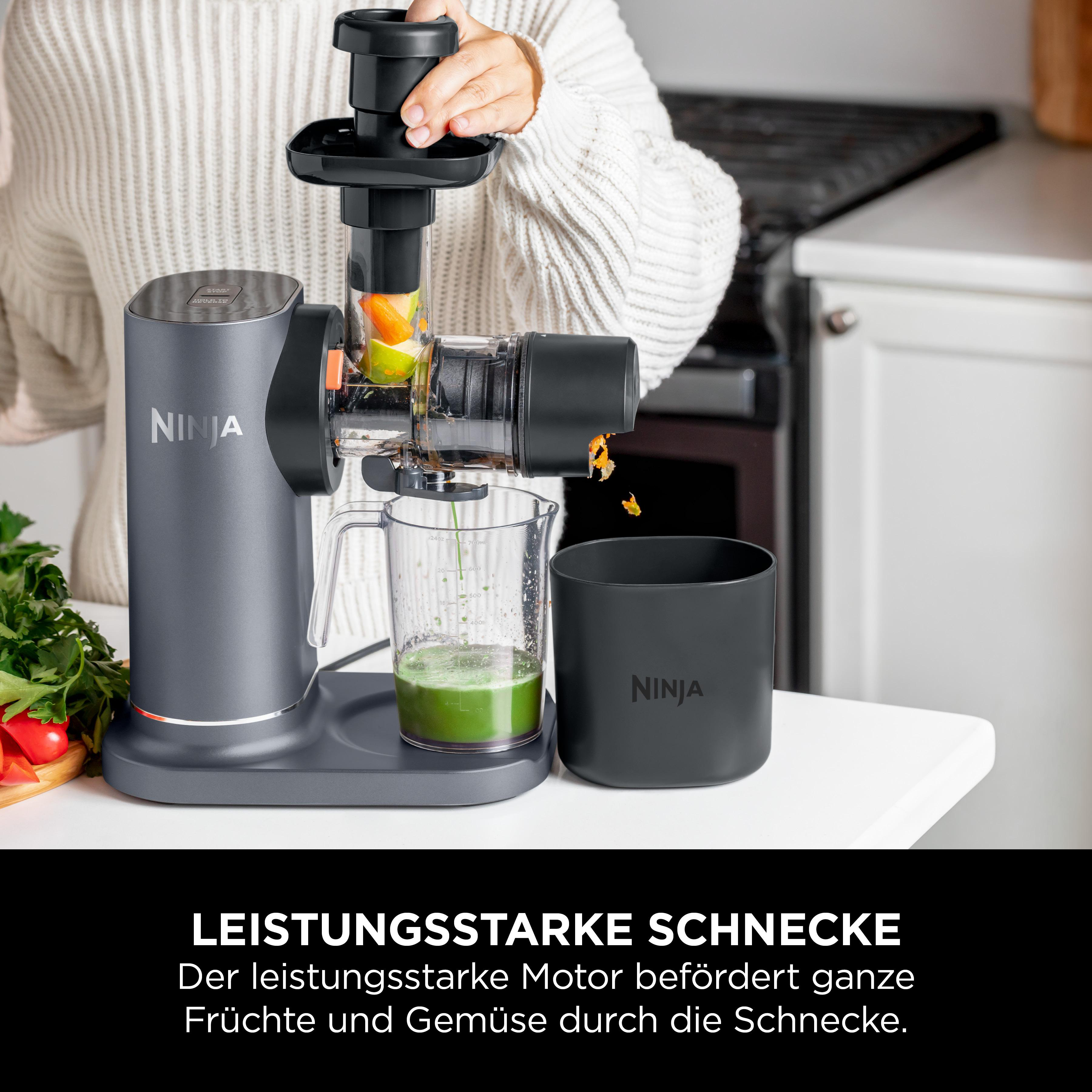 Person benutzt Ninja Entsafter, Saft im Glas, Behälter für Fruchtfleisch.