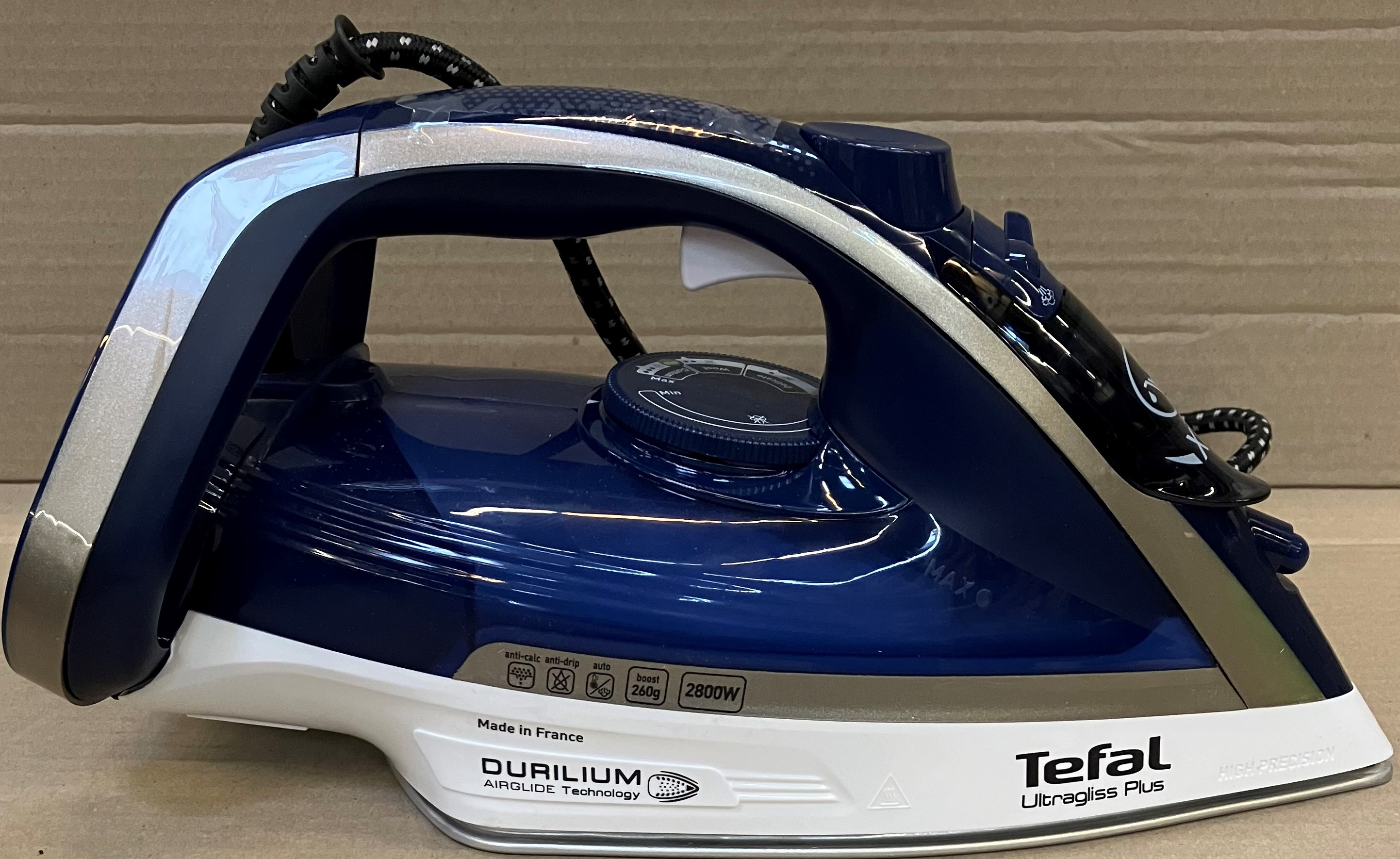 Niebiesko-białe żelazko Tefal Ultragliss Plus na białej powierzchni.