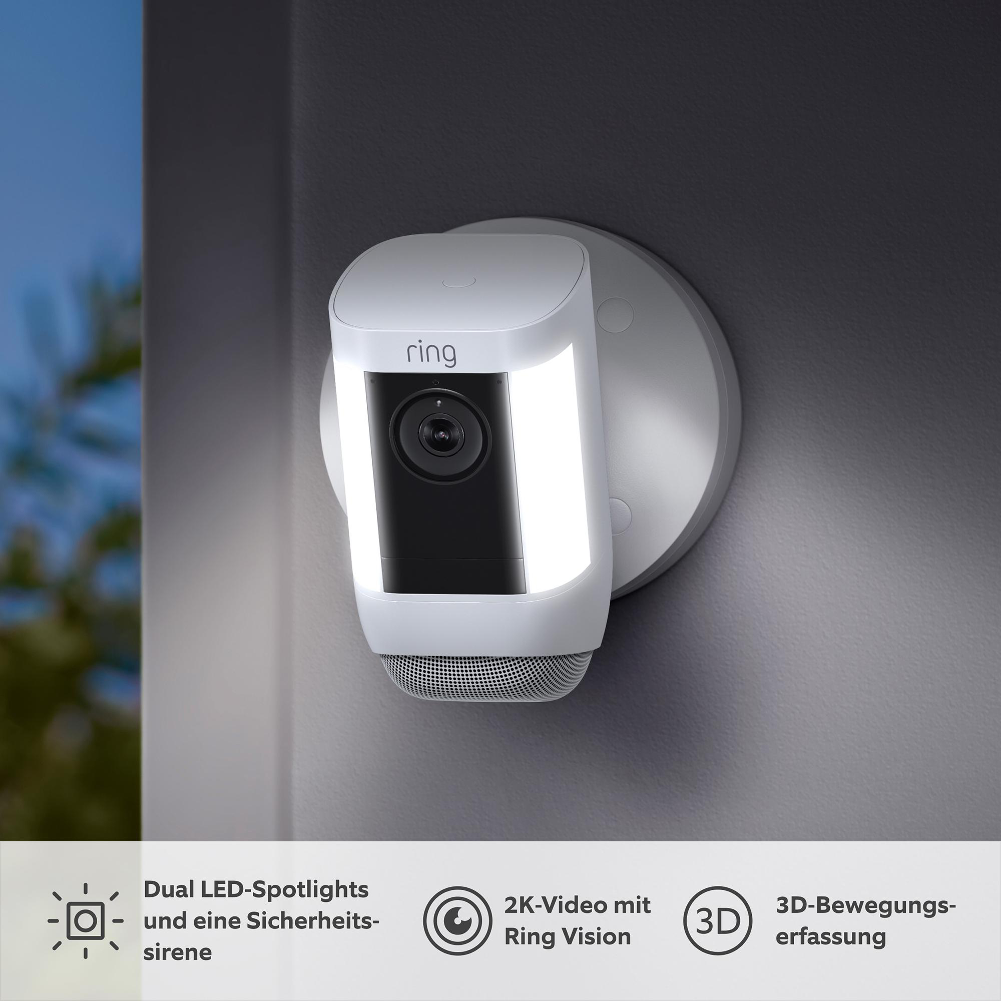 Ring-Überwachungskamera an einer Wand montiert, mit LED-Strahlern und einem Lautsprechergitter.