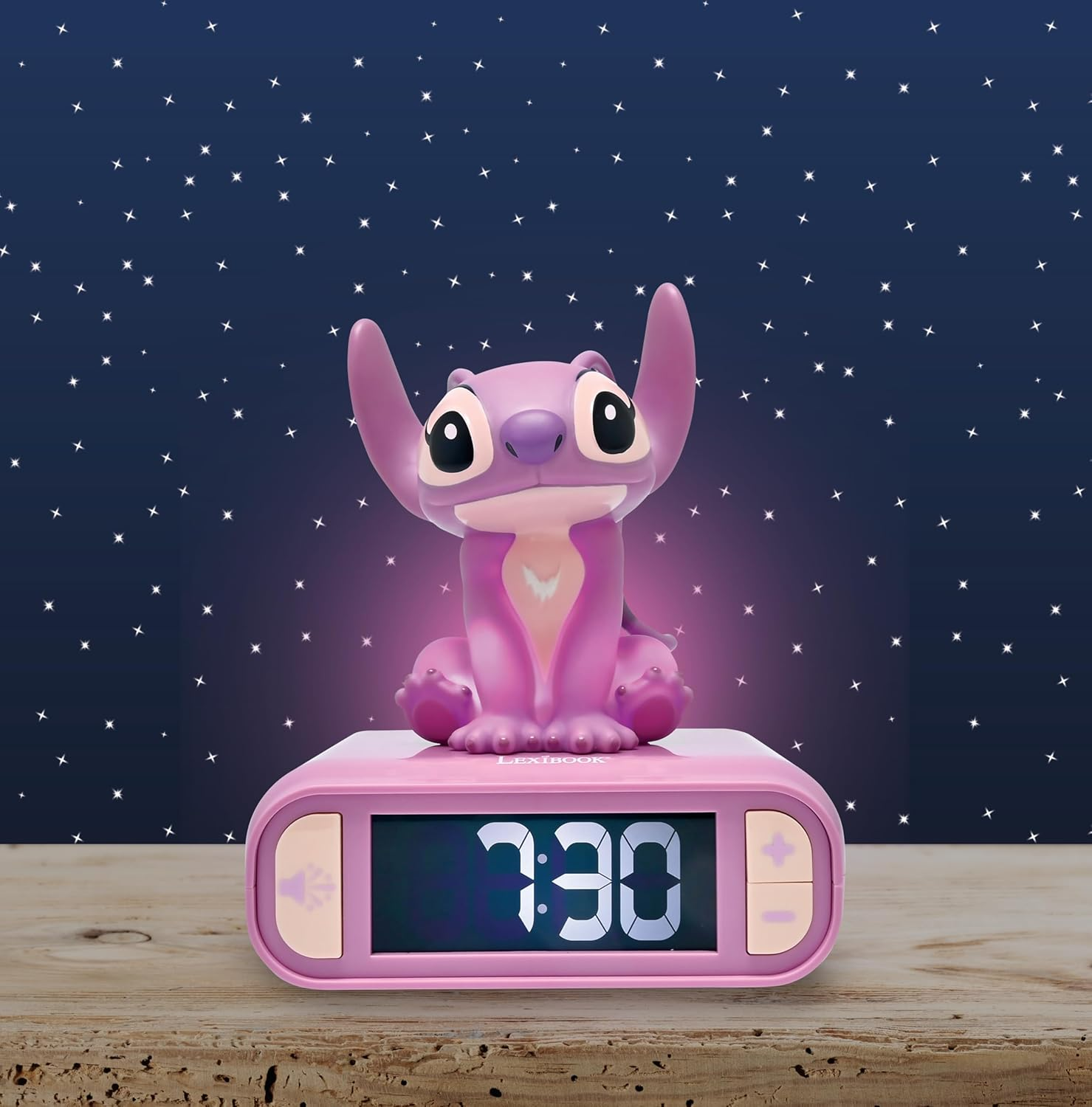 Luz nocturna de Stitch en un despertador rosa sobre una superficie de madera.