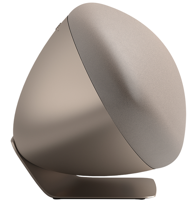 Beżowy głośnik pochylony w lewo, o zakrzywionej konstrukcji.