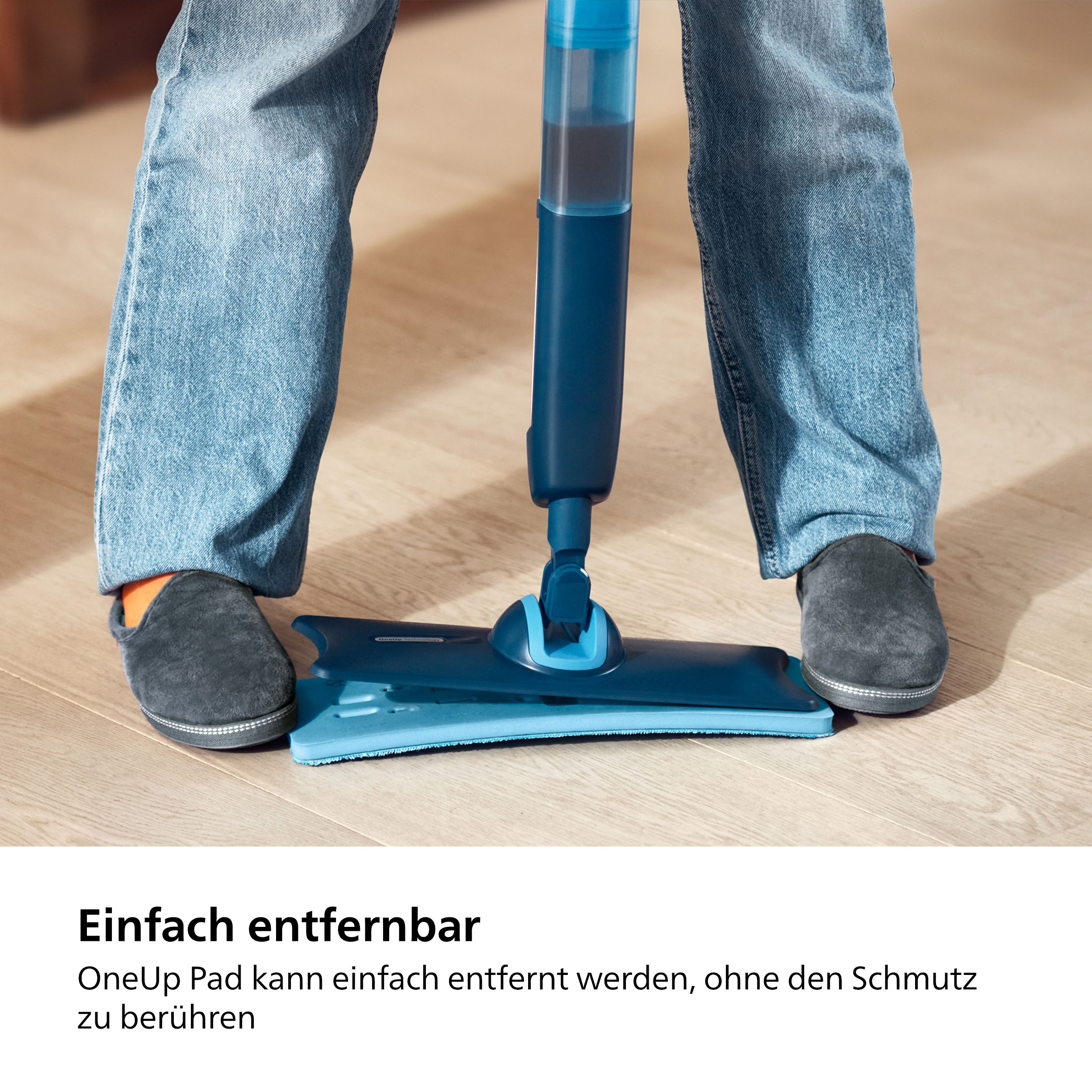 Eine Person in Jeans und Hausschuhen benutzt einen blauen Wischmopp auf einem Holzboden.