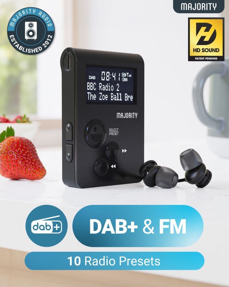 Radio nera con schermo che mostra l'ora e la stazione radio. Auricolari a destra. Fragola a sinistra.