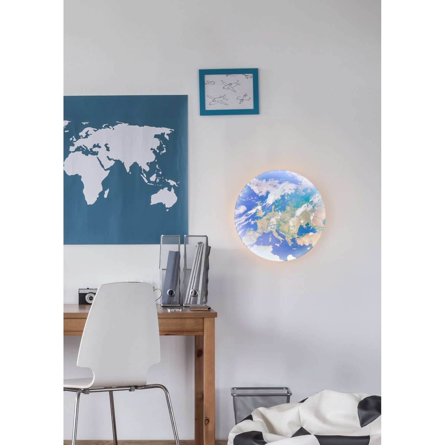 Una stanza con una mappa del mondo e una lampada a globo sulla parete, una scrivania e una sedia.