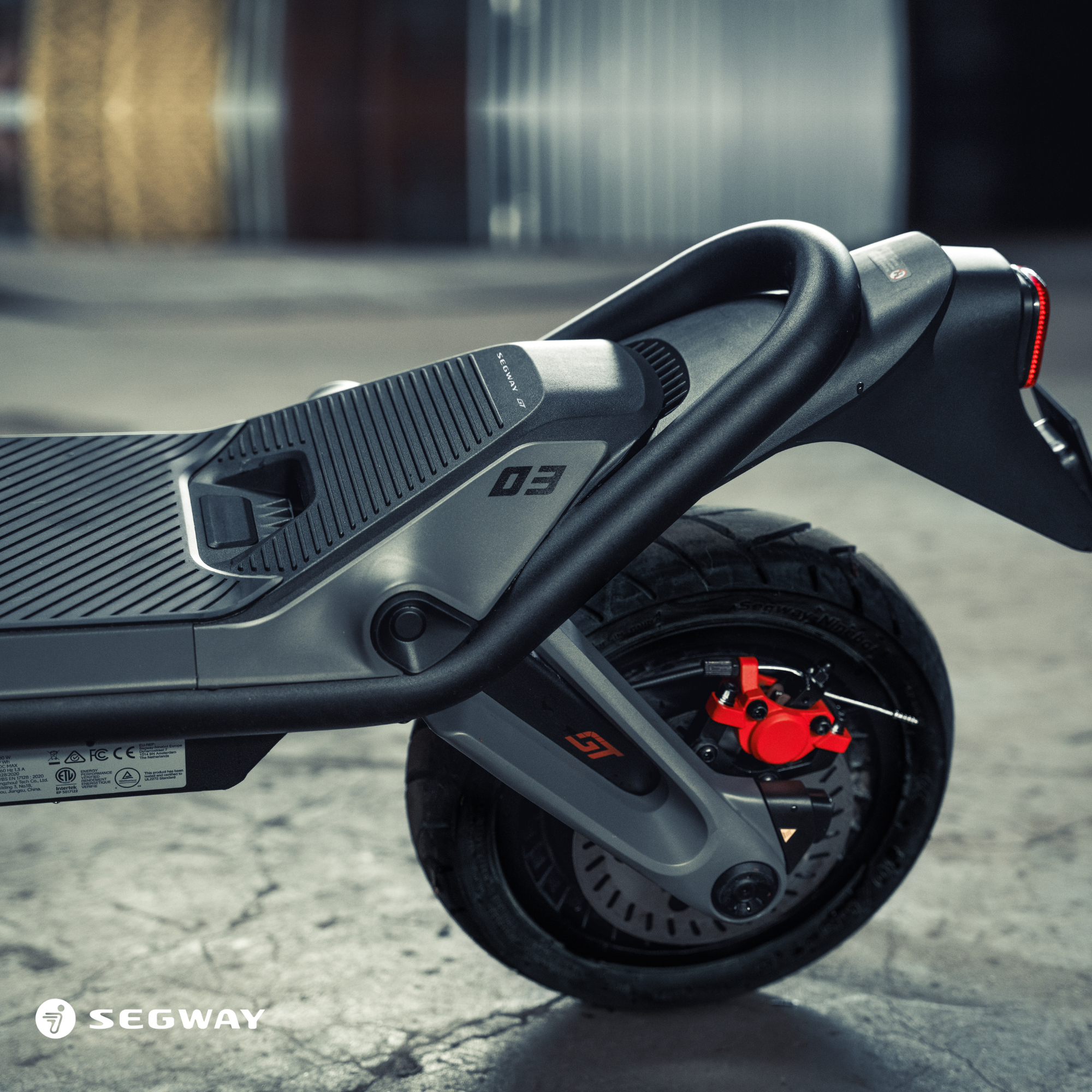 Ein grauer und schwarzer Roller mit einem Segway-Logo auf einer Oberfläche.
