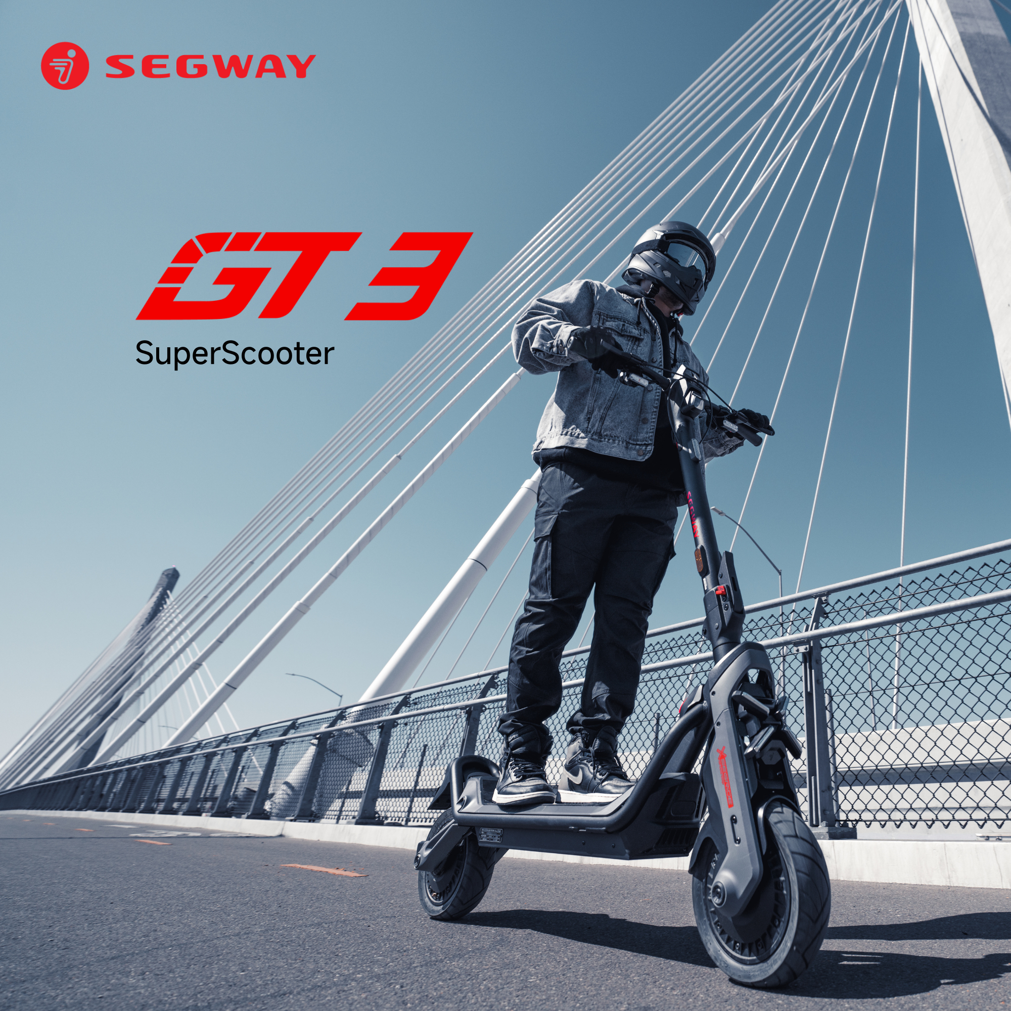 Ein Mann fährt mit einem Segway GT3 SuperScooter auf einer Brücke. Der Segway ist schwarz und grau mit roten Akzenten.