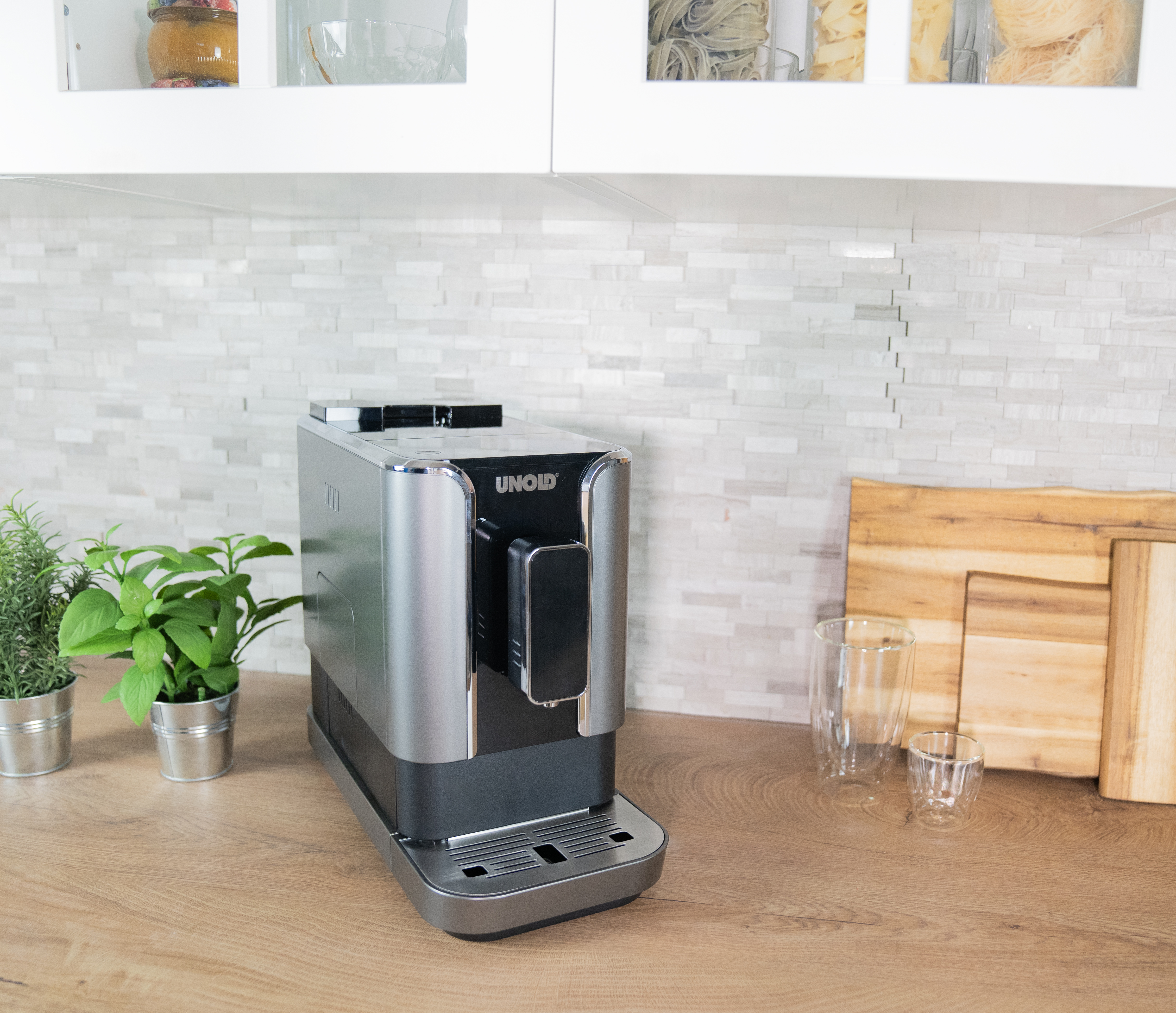 Silber-schwarze Espressomaschine auf einer Holztheke, Küchenhintergrund.