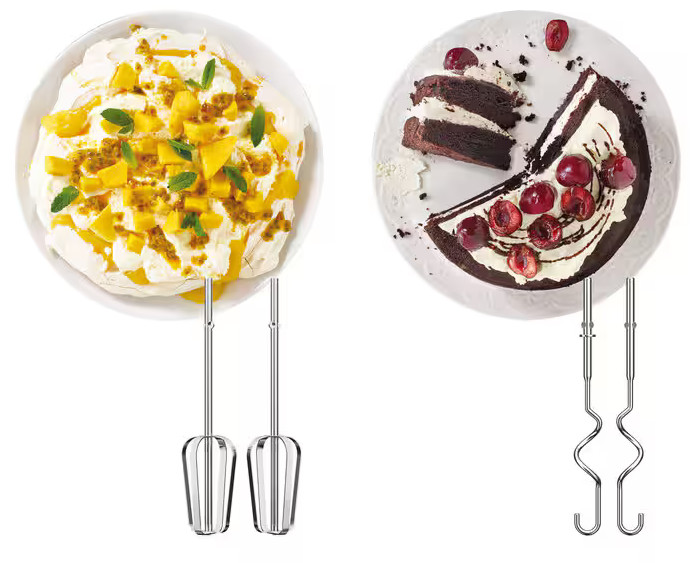 Dwa talerze z deserami, jeden z mango i bezą, drugi z ciastem i wiśniami.