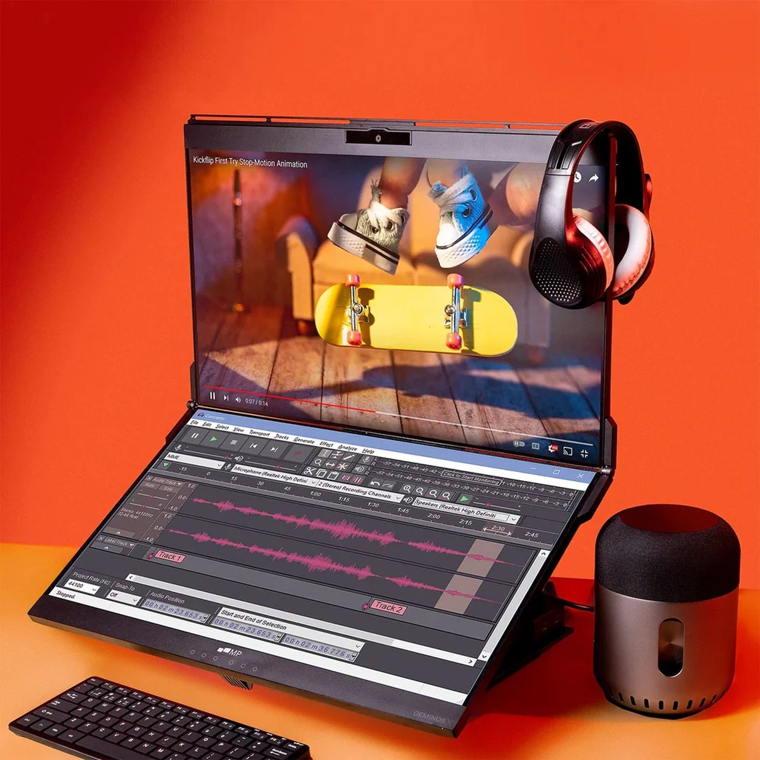 Un ordinateur portable affichant une interface d'édition vidéo et audio. Casque et haut-parleur présents. Fond orange.