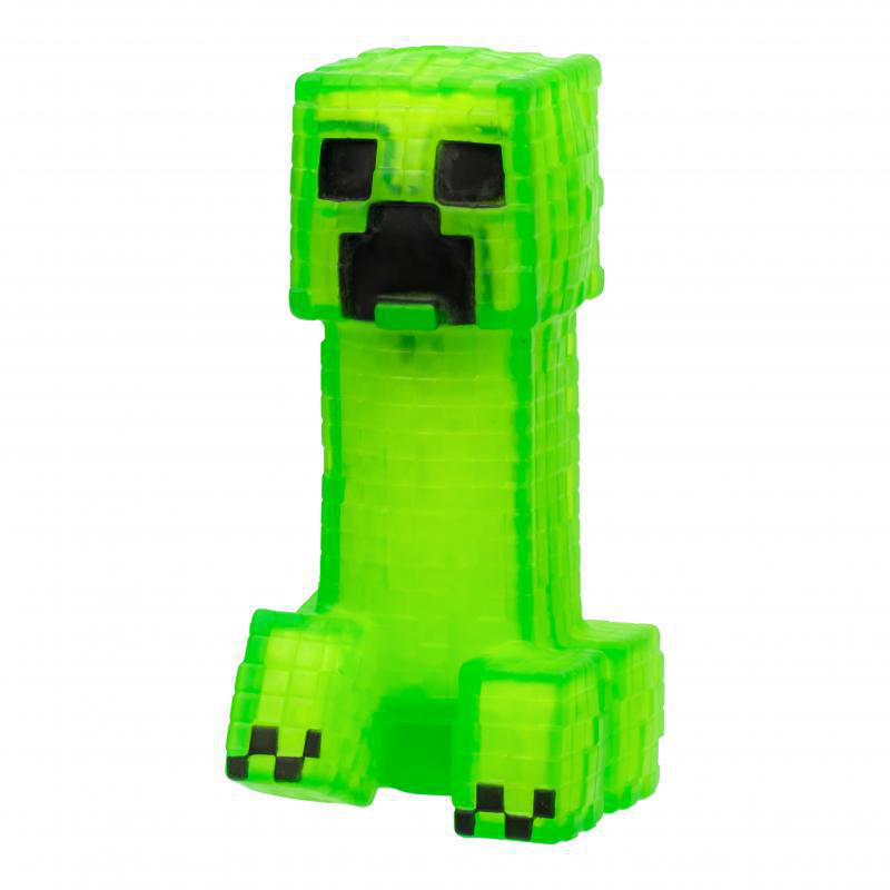 Ein grünes Minecraft Creeper-Spielzeug steht aufrecht auf weißem Hintergrund. Es ist verpixelt.
