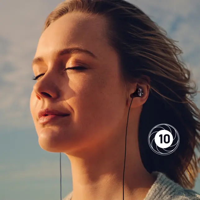 Kobieta ze słuchawkami uśmiecha się, oczy zamknięte, na tle błękitnego nieba. W rogu liczba '10'.