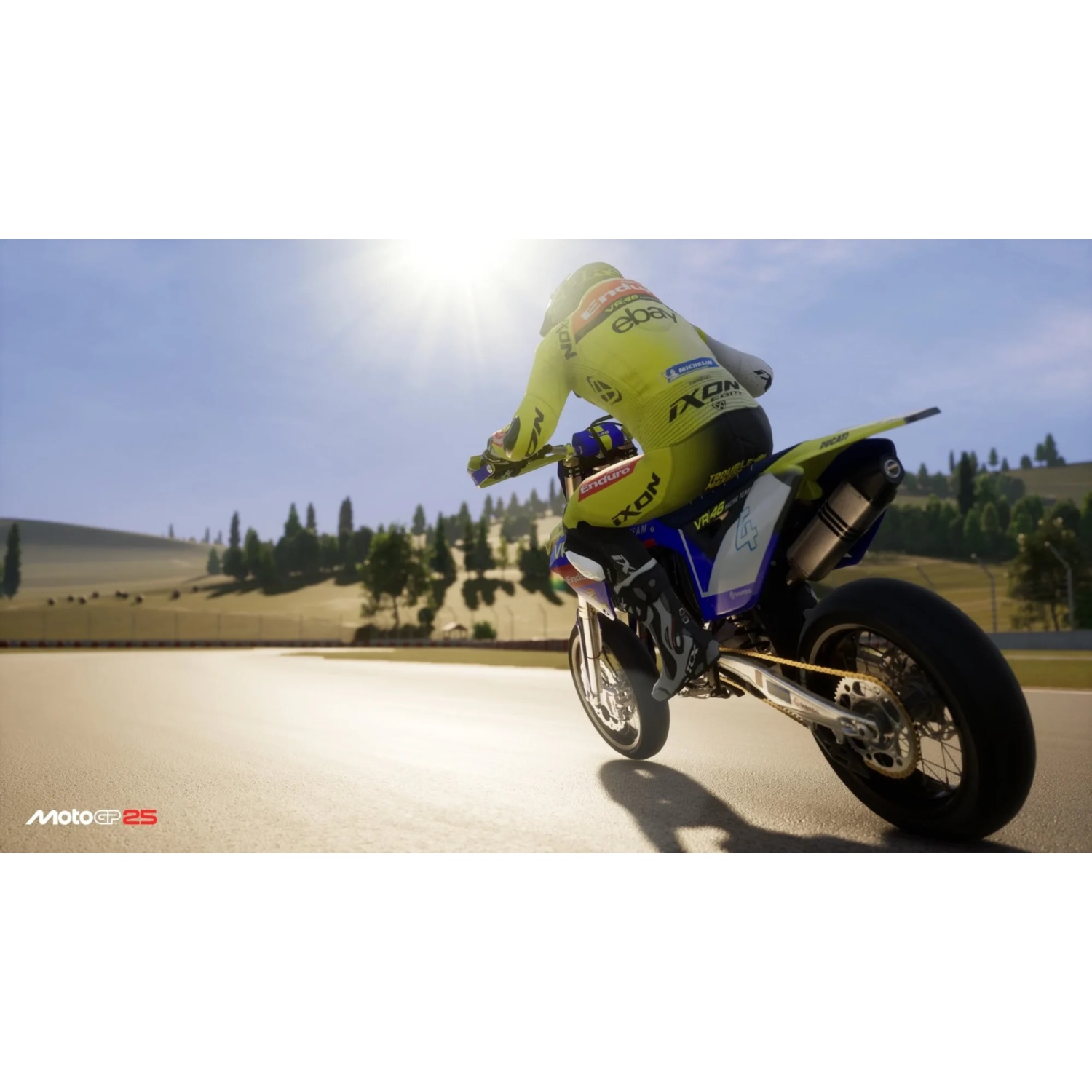 A motorcycle racing on a track. The rider is wearing a yellow and black racing suit. The sun is shining.