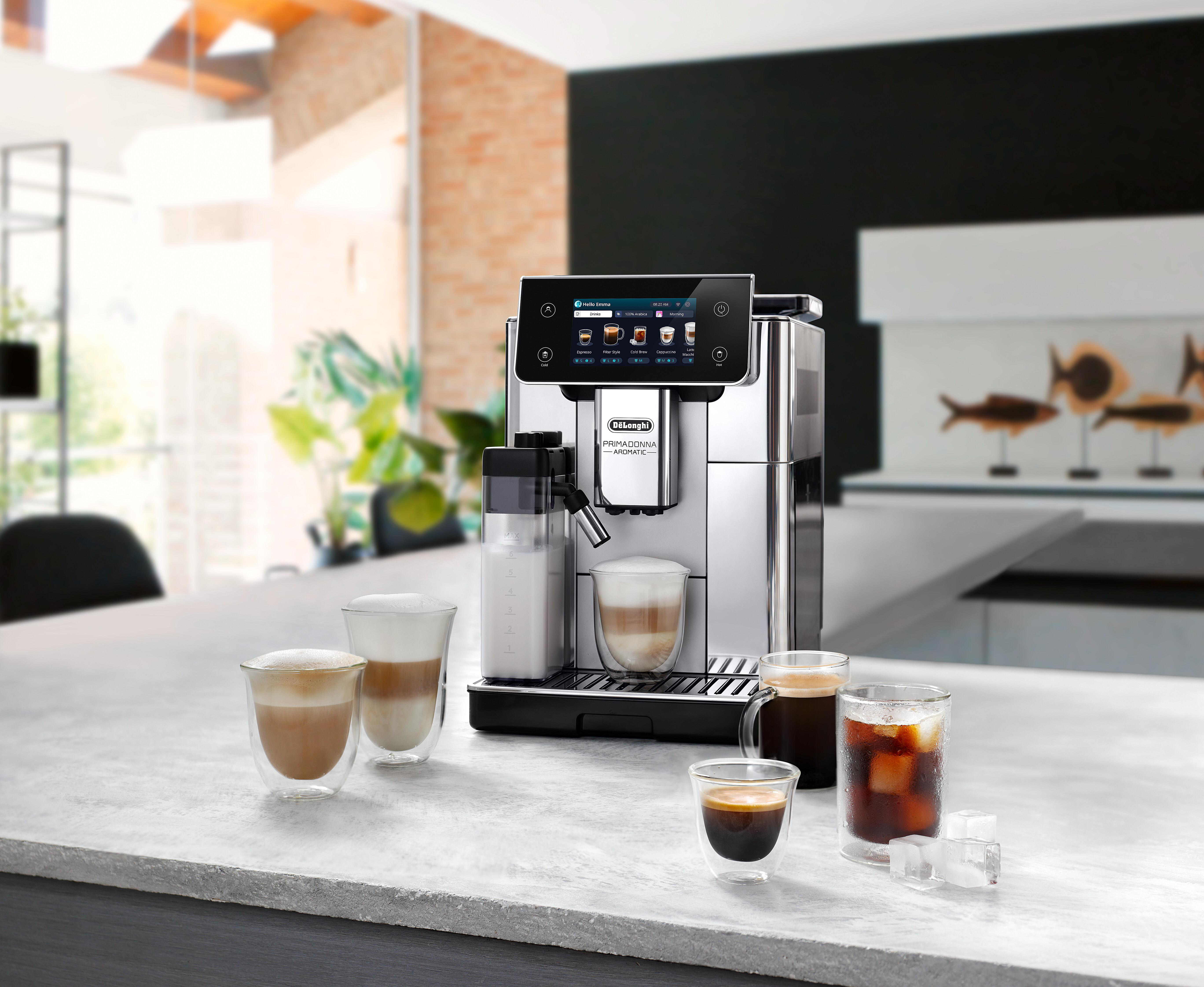 Eine silberne und schwarze Kaffeemaschine mit Kaffeetassen auf einer weißen Oberfläche.