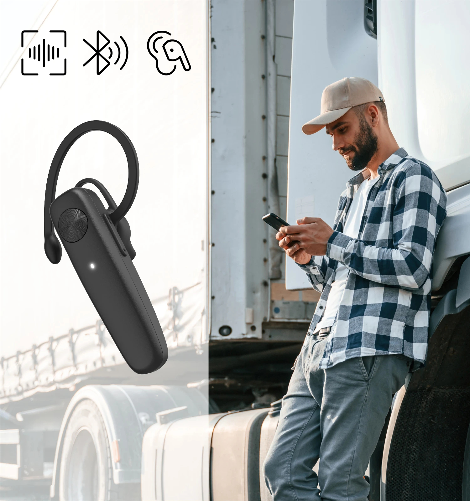 Mężczyzna z brodą używający zestawu słuchawkowego Bluetooth obok ciężarówki.
