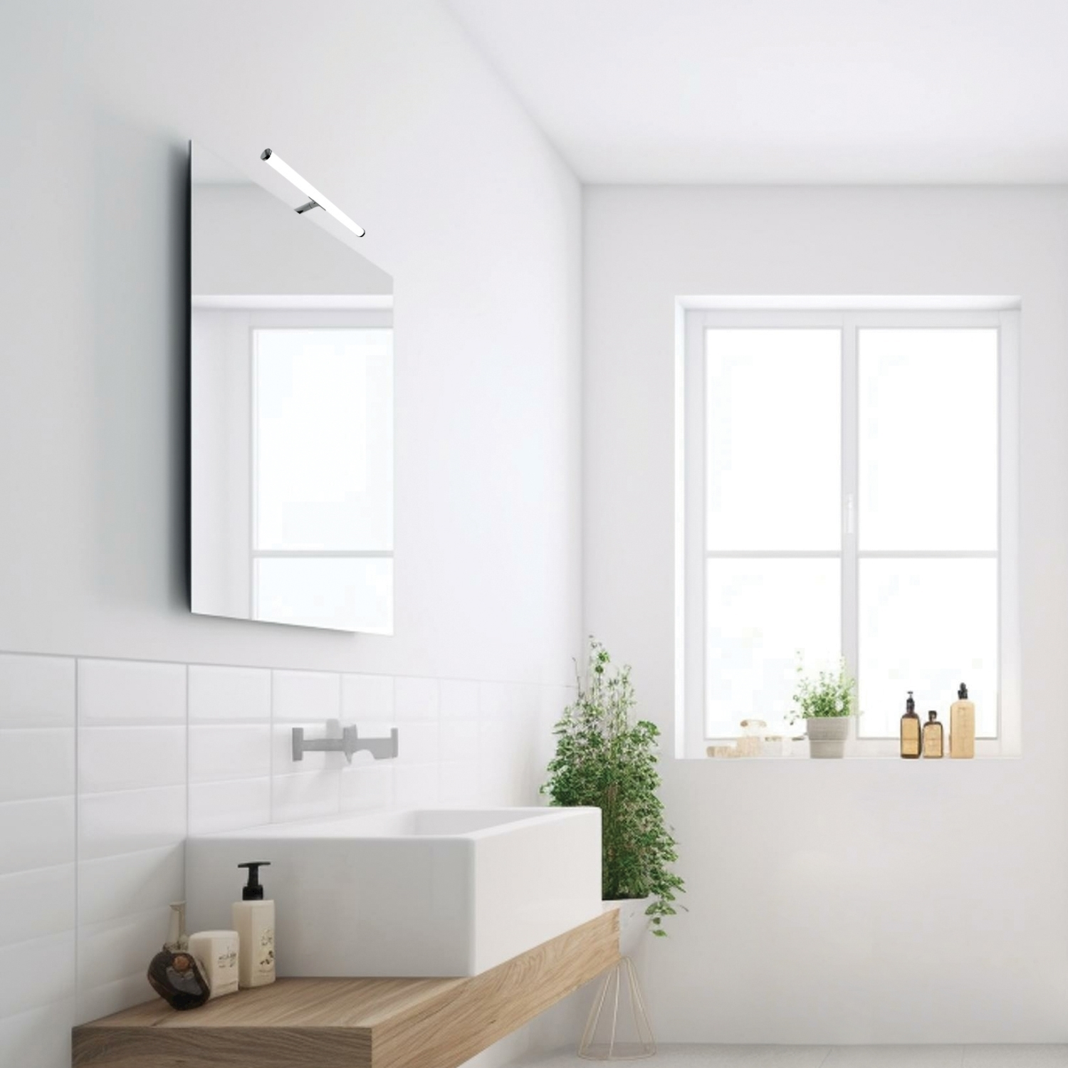 Bagno con specchio, lavandino e finestra.