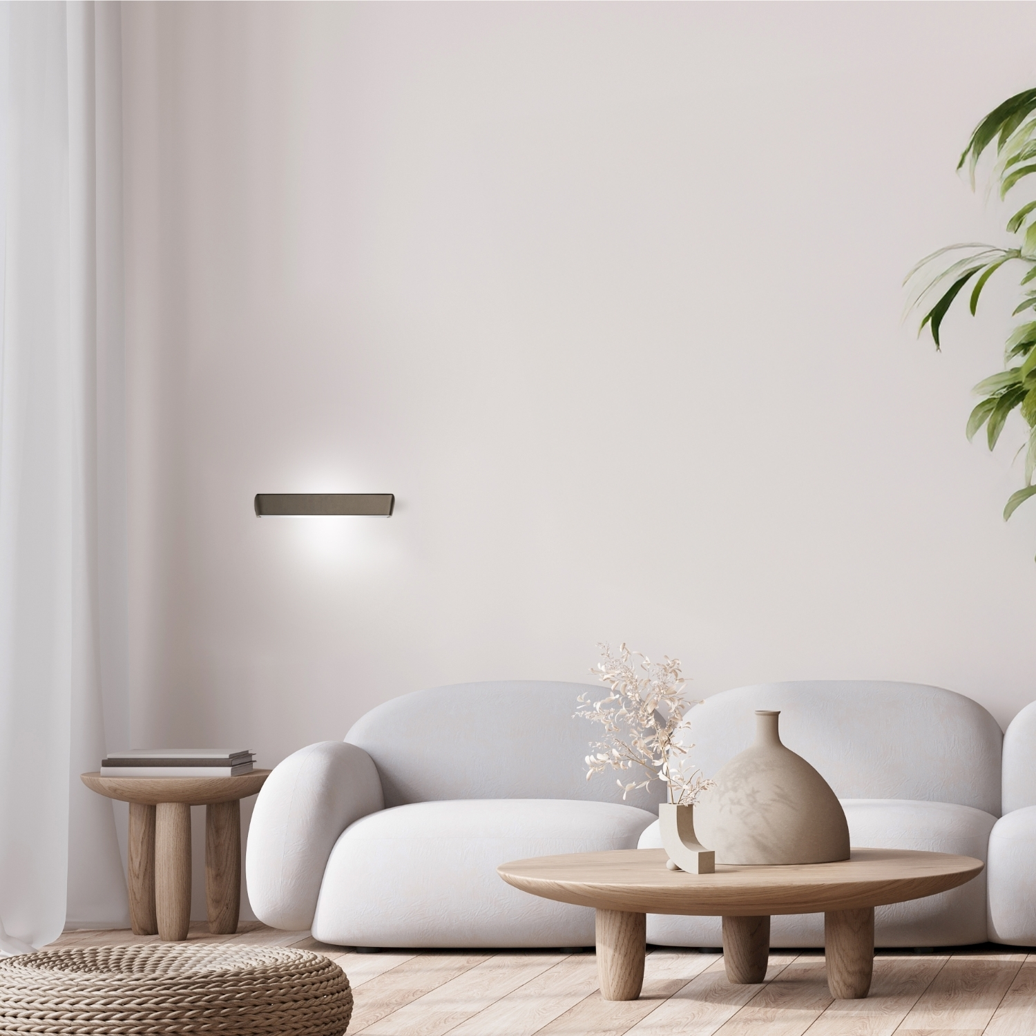 Un soggiorno con un'applique a parete, un divano e oggetti decorativi.