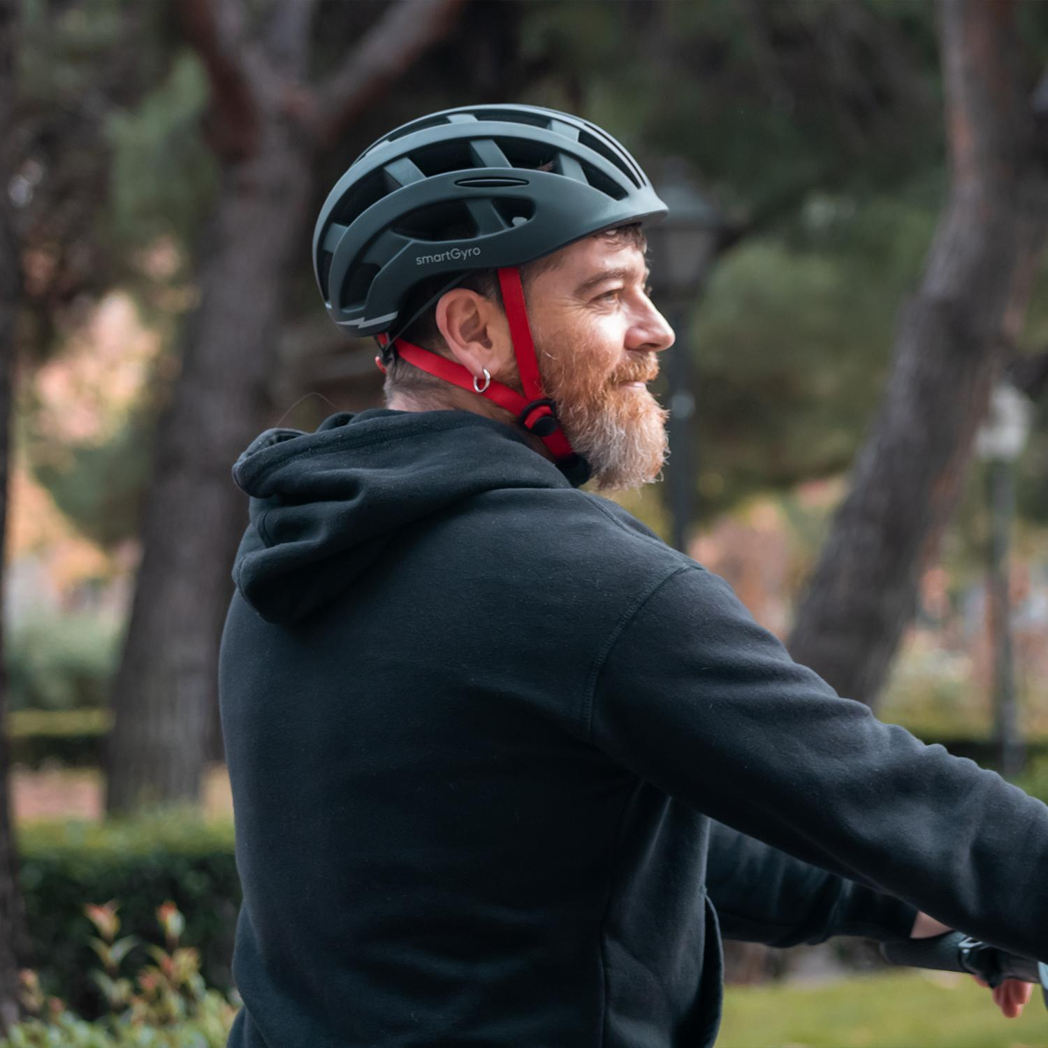 Un hombre con barba que lleva un casco mientras monta en bicicleta.