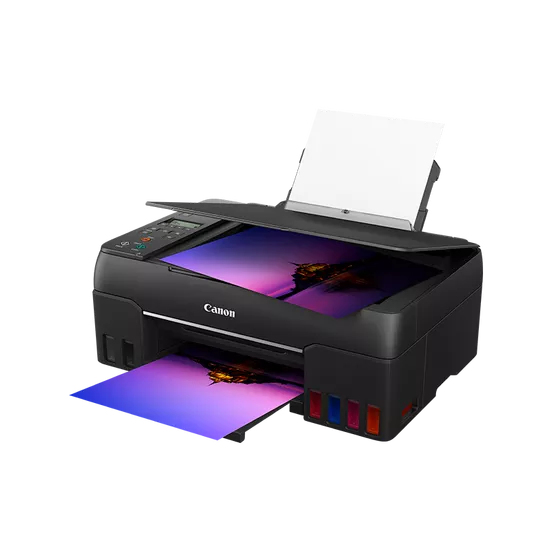 Se muestra una impresora Canon negra. Se está imprimiendo una imagen colorida. La impresora tiene una parte superior abierta con papel.