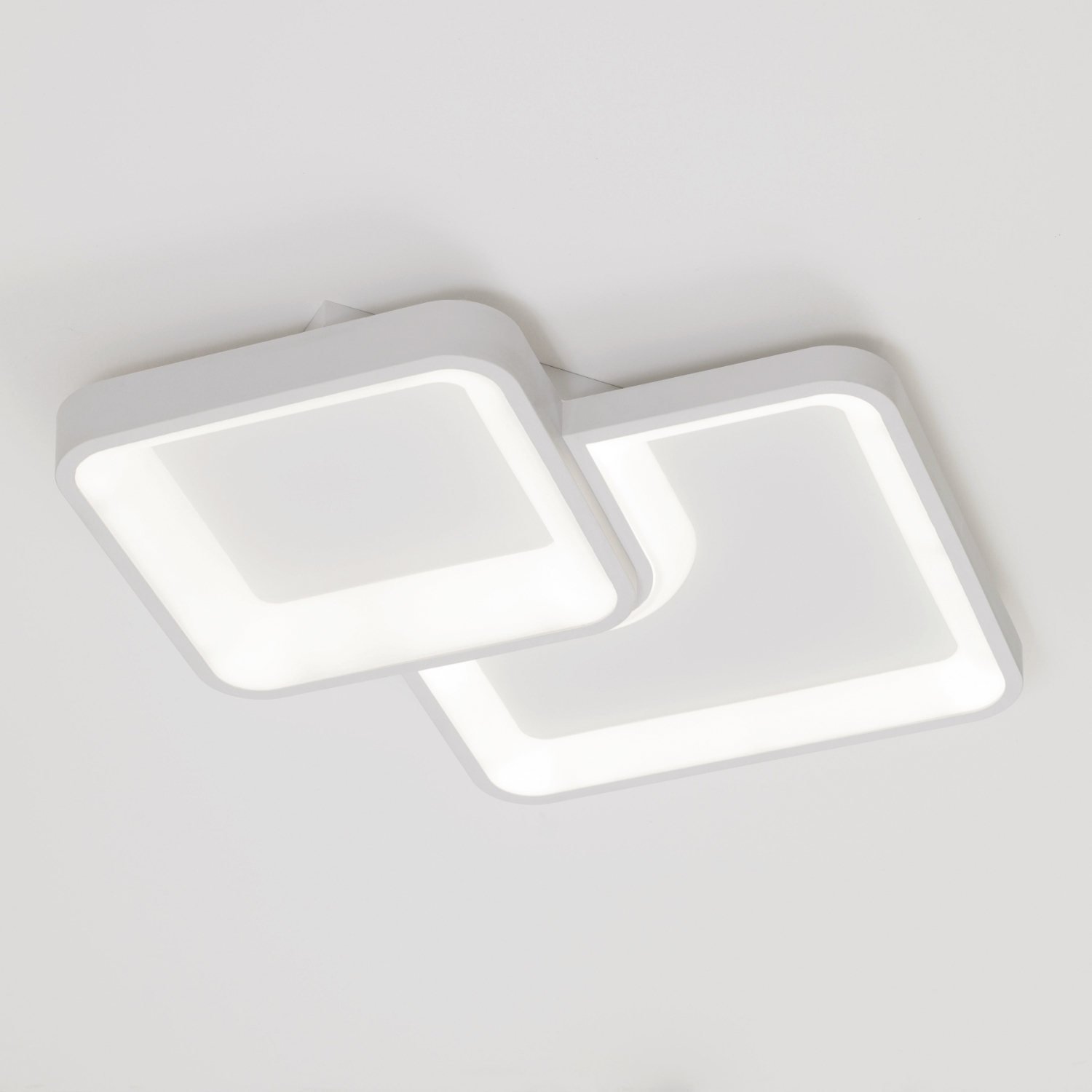 Lampada da soffitto bianca con due pannelli quadrati luminosi. Ogni pannello ha una forma quadrata arrotondata.