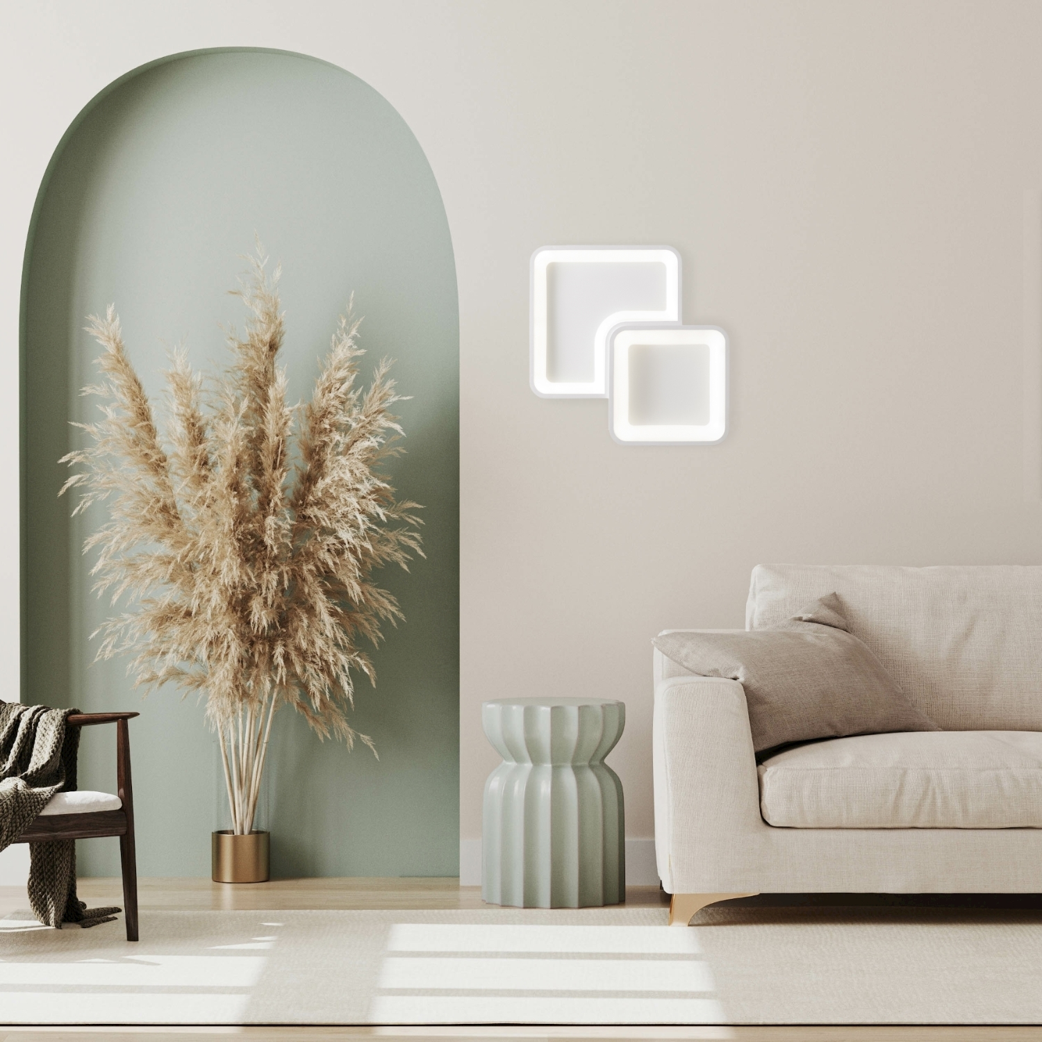 Interno con divano beige, erba della pampa, sedia in legno, tavolino rotondo e due luci quadrate.