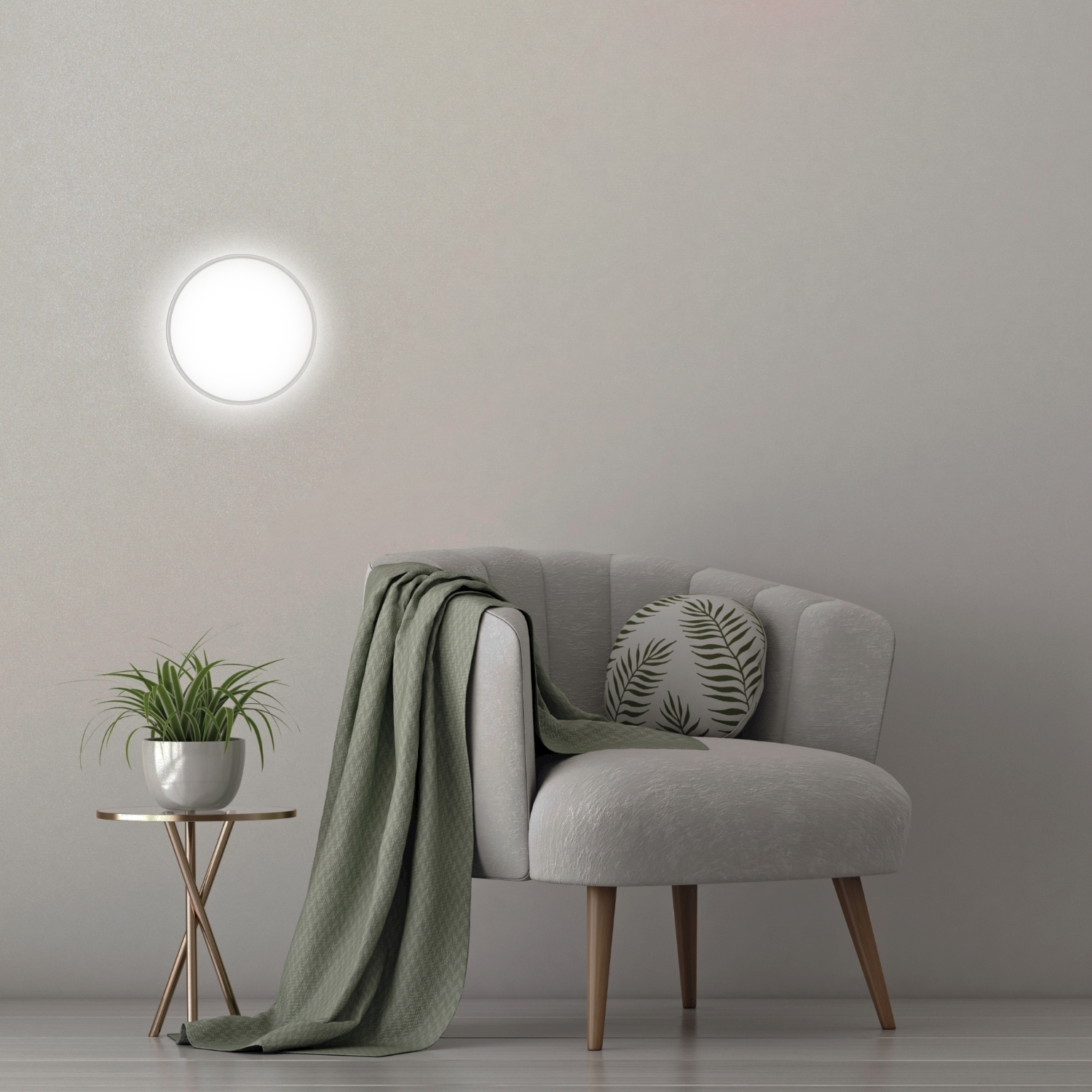 Una poltrona grigia con una coperta verde e un cuscino. Una pianta e una lampada a lato.