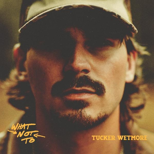 Mann mit Schnurrbart und Hut. Albumcover für 'What Not To' von Tucker Wetmore. Der Titel ist gelb.