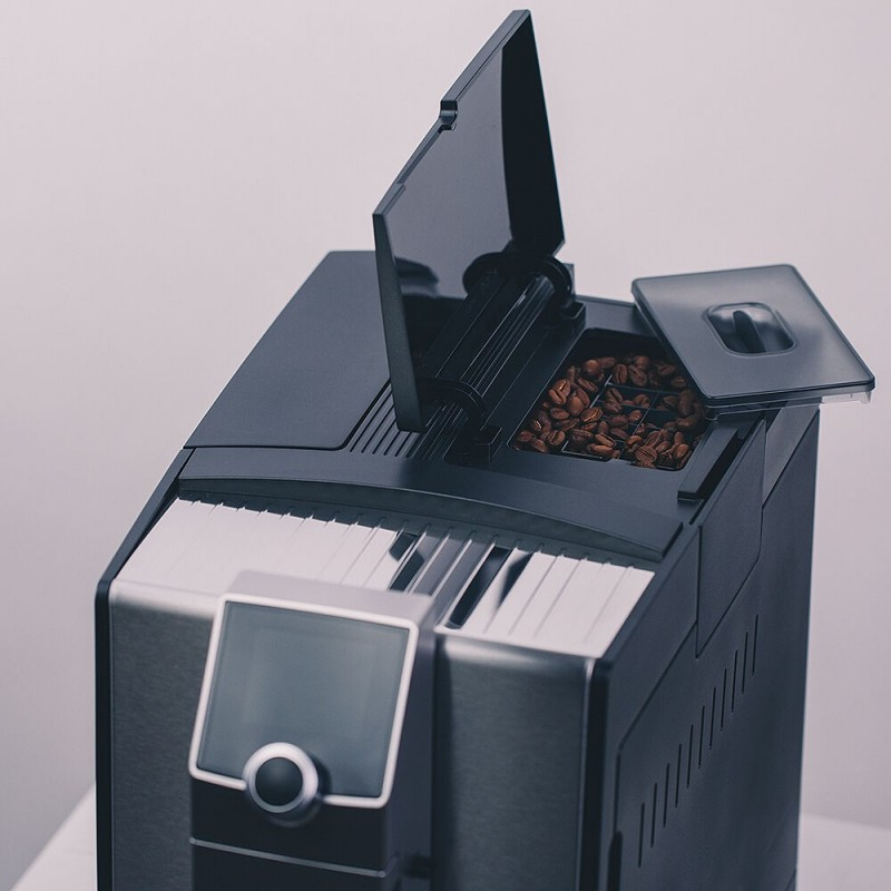 Czarny i srebrny ekspres do kawy z otwartym pojemnikiem na ziarna, ukazujący ziarna kawy w środku.