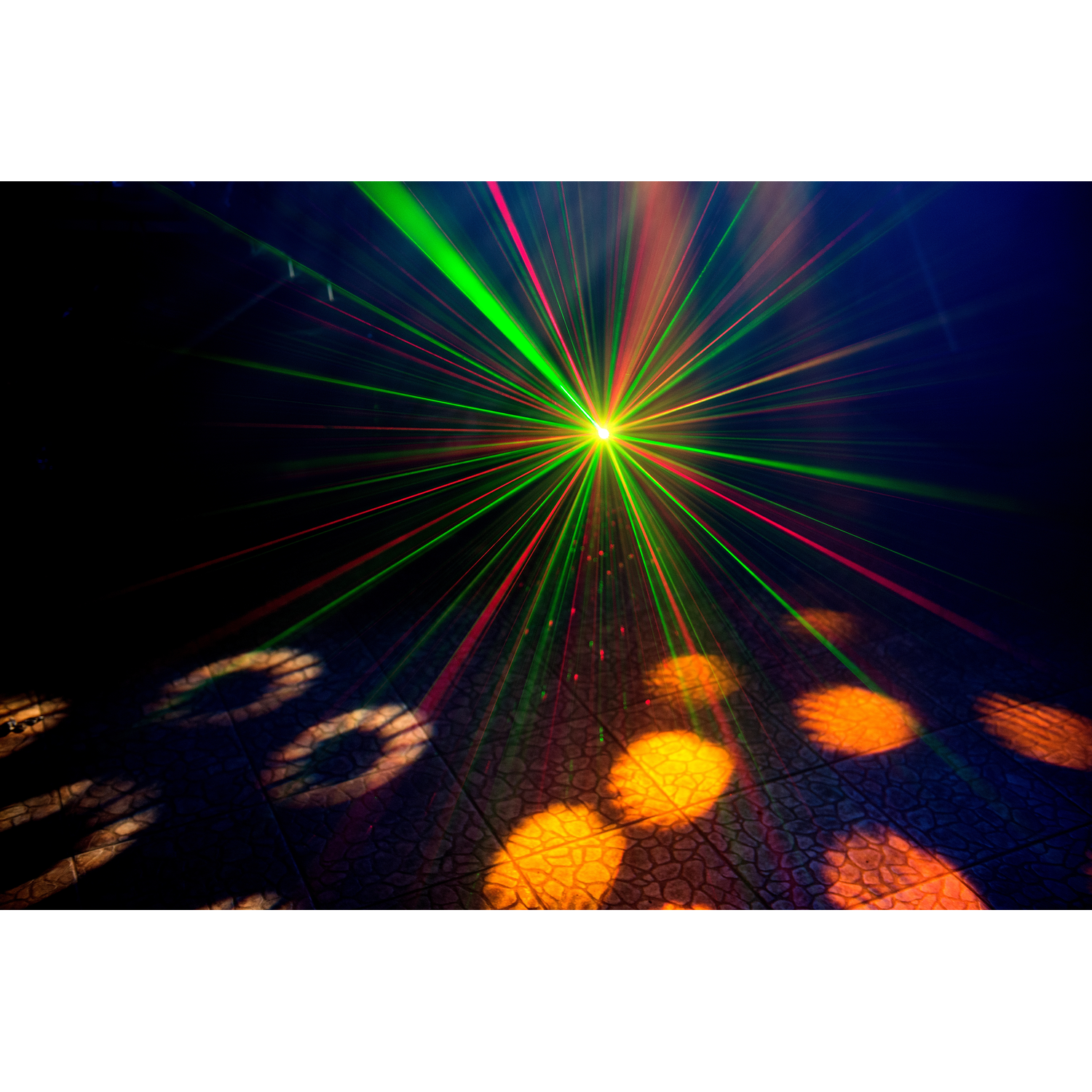 Een donkere kamer met groene en rode laserstralen en lichtvlekken.