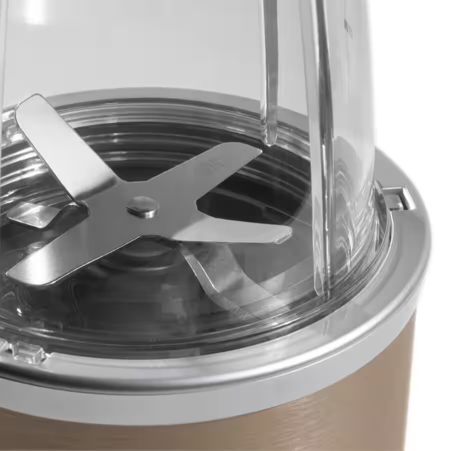 Nahaufnahme einer Mixer-Klinge in einem transparenten Behälter auf goldener Basis.