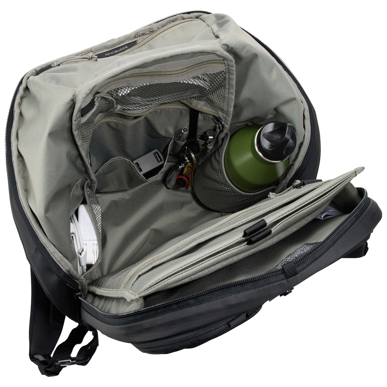 À l'intérieur d'un sac à dos, montrant des compartiments, une bouteille d'eau et d'autres articles.