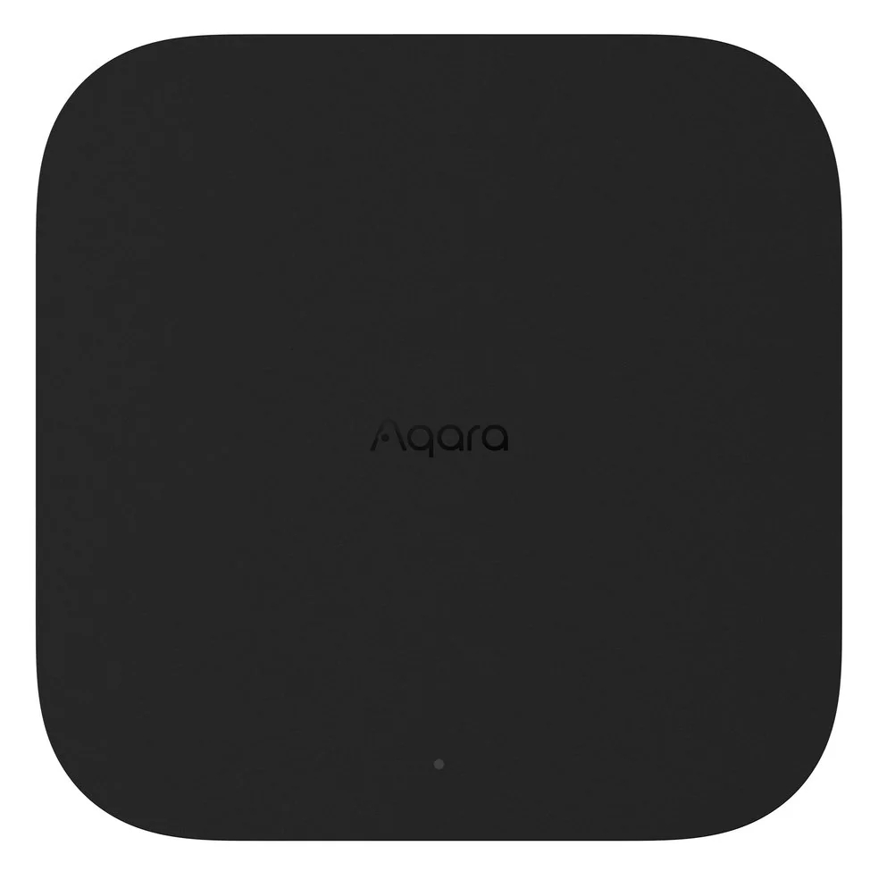 Czarny hub inteligentnego domu Aqara, kwadratowy z zaokrąglonymi rogami, logo pośrodku.