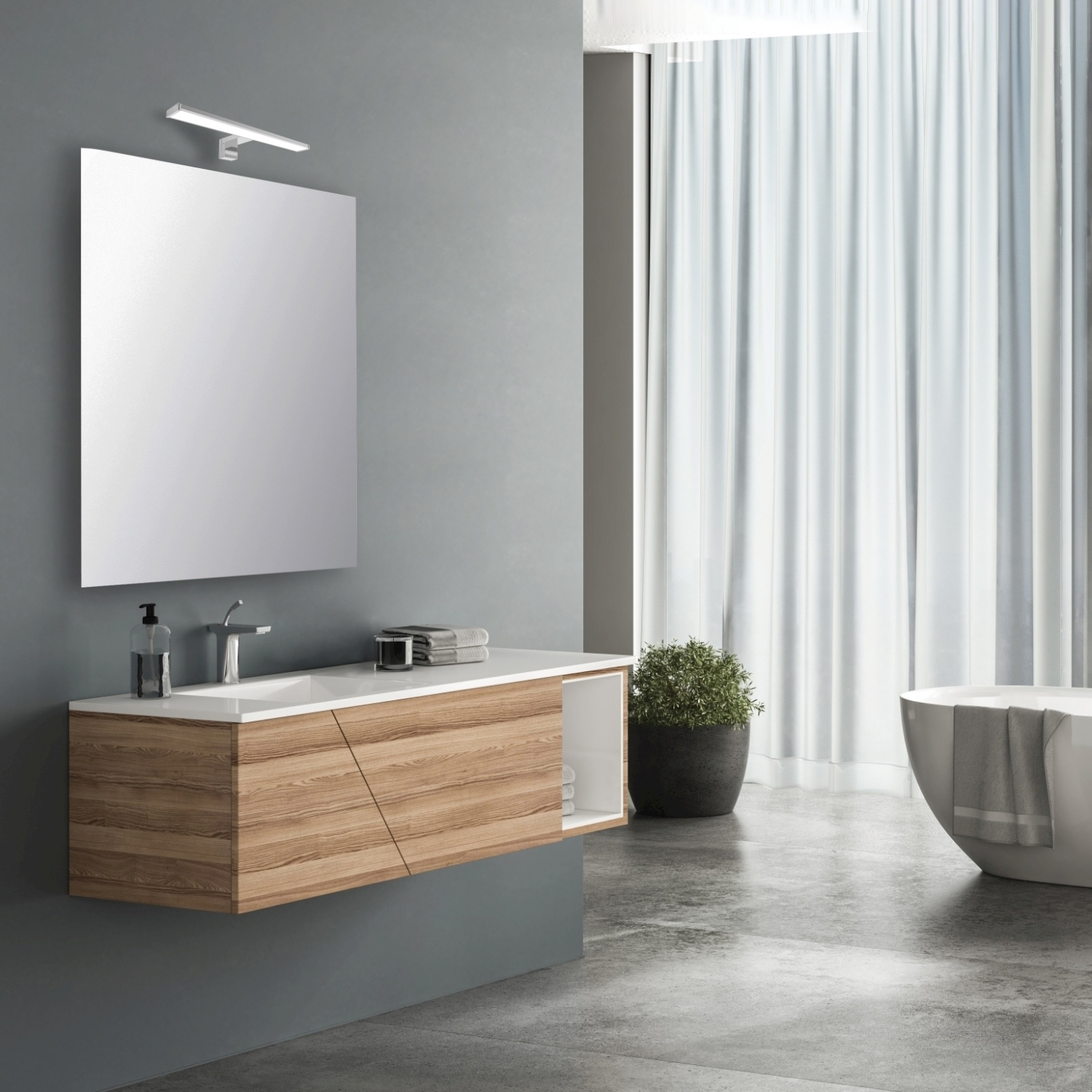 Bagno con mobile in legno, specchio e vasca. Il muro è grigio.