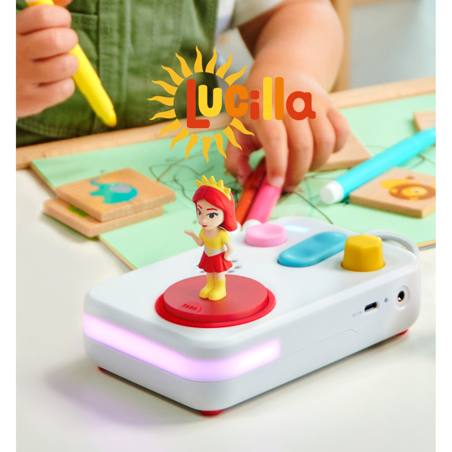 Un bambino gioca con un giocattolo su un tavolo. Una figura si trova su un dispositivo bianco con pulsanti e luci.