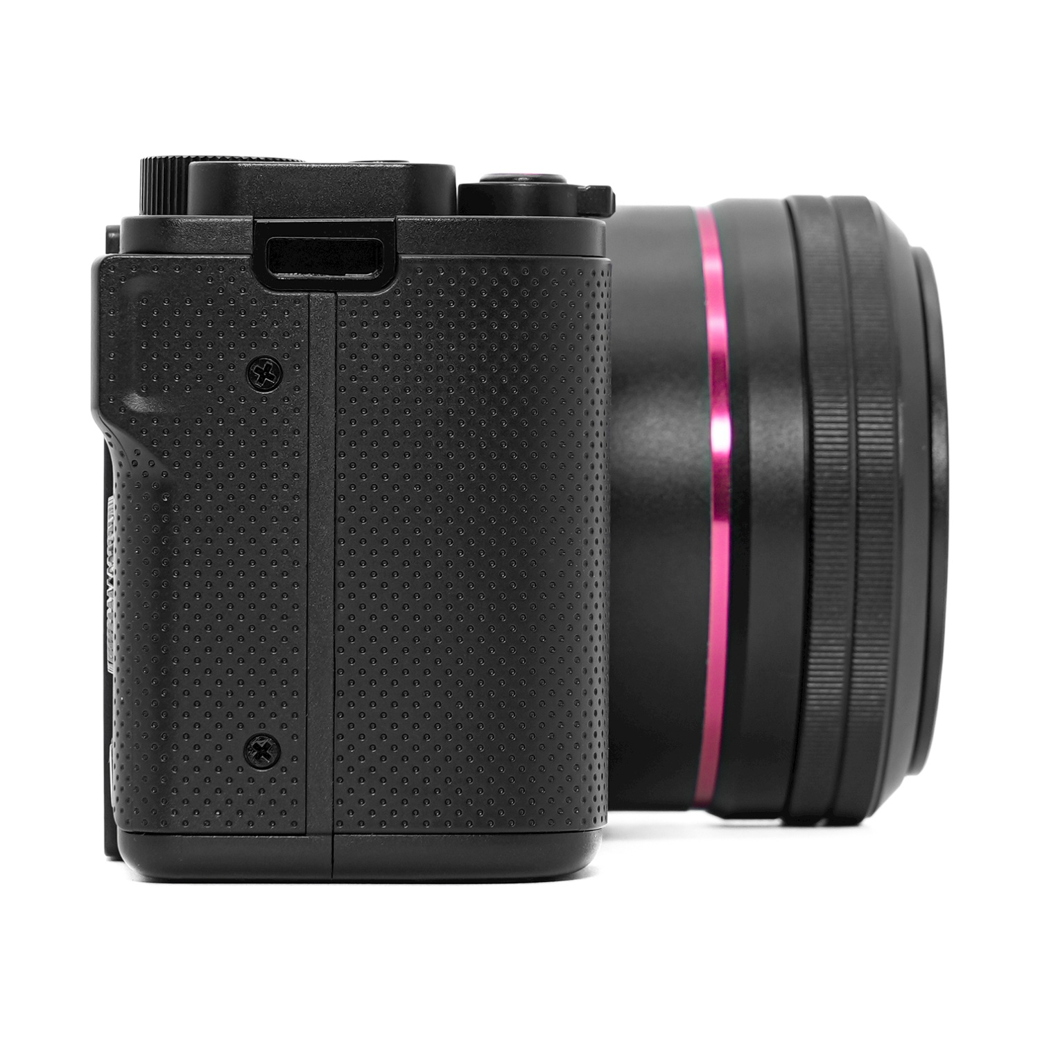 Fotocamera nera con corpo testurizzato e obiettivo con anello rosa. La fotocamera è su sfondo bianco.