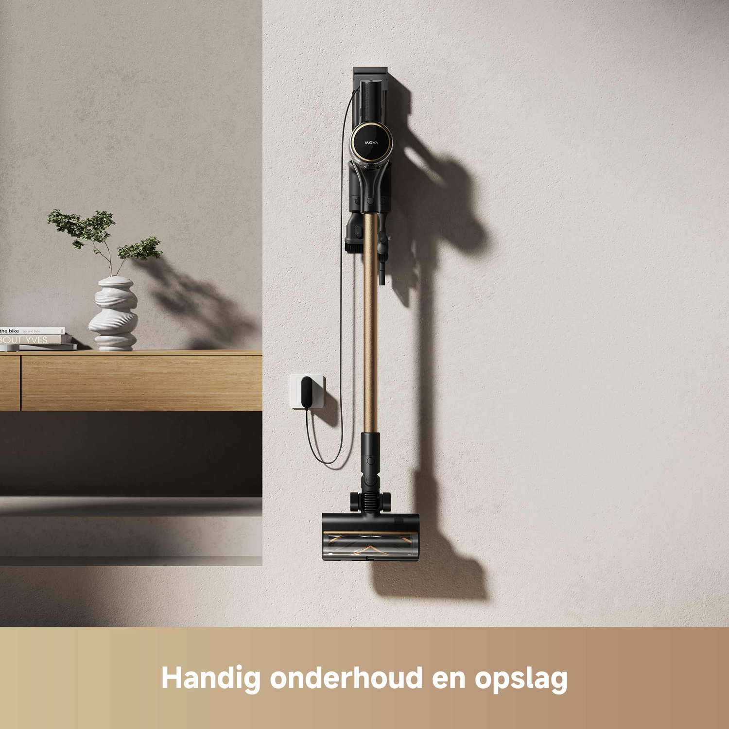 A vacuum cleaner hangs on a wall. There is a vase with a plant, books, a wooden shelf, and a power outlet in view.