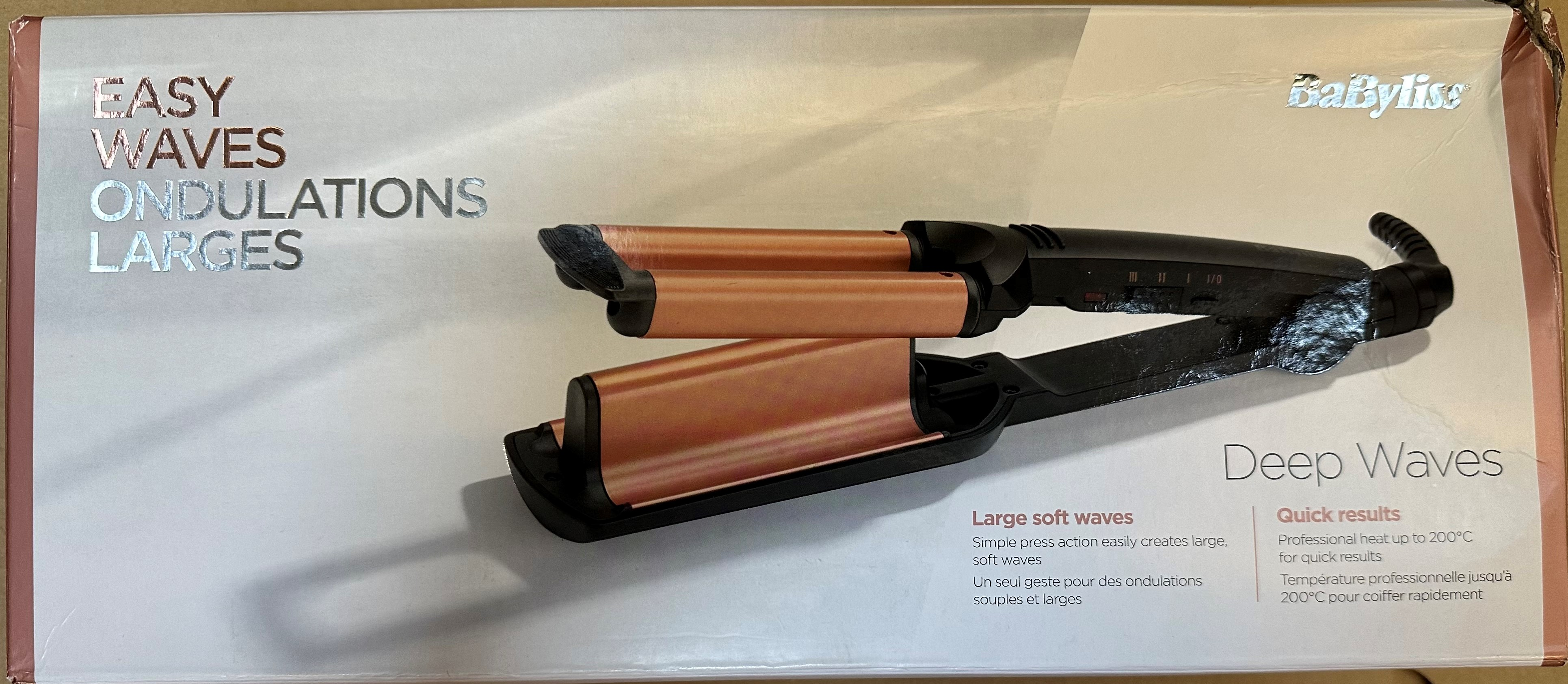 Różowo-złota falownica do włosów na białym pudełku z tekstem.