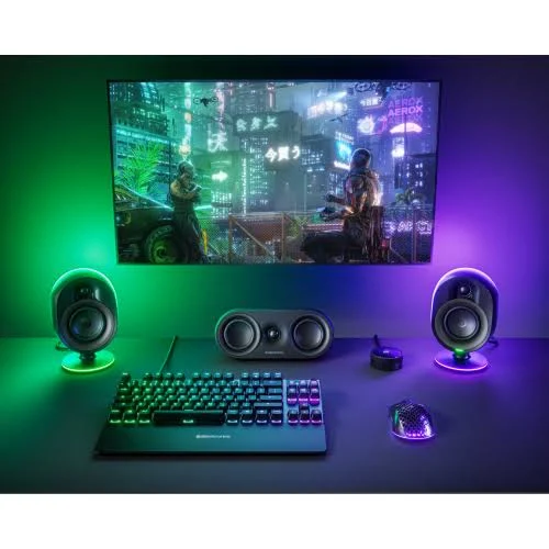 Una configuración de juego con altavoces, teclado y ratón. Una pantalla muestra una escena futurista. Luces de colores iluminan el escritorio.