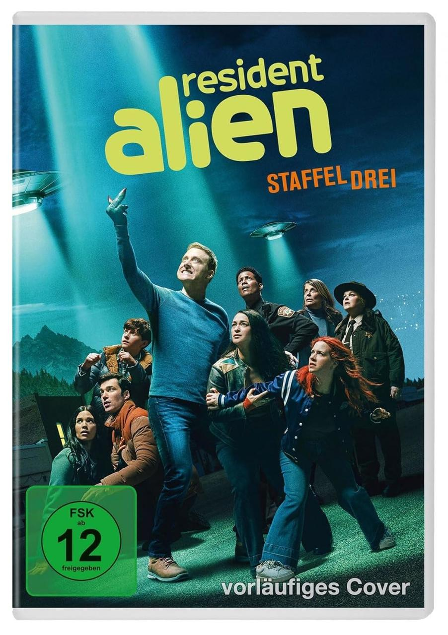 DVD-Cover: 'Resident Alien' Besetzung. Leute schauen nach oben. Blauer Hintergrund mit fliegenden Untertassen.