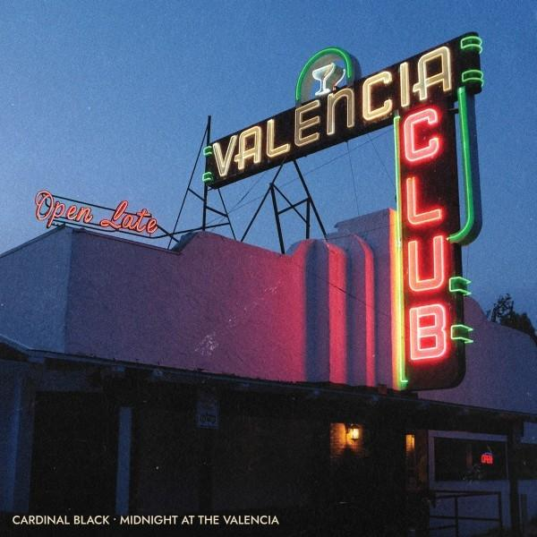 Nachtaufnahme eines Clubschilds mit der Aufschrift VALENCIA CLUB in Neon. Rosa Gebäude darunter.