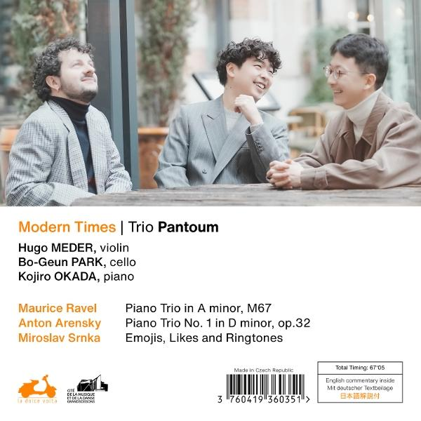 Drei Musiker lächeln, mit der Rückseite eines Albumcovers im Vordergrund.