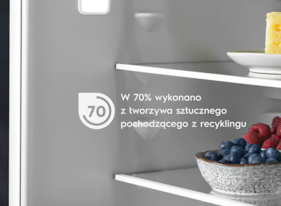 Wnętrze lodówki. Półki z jedzeniem: jagody, ser. Tekst wskazuje 70% plastiku z recyklingu.