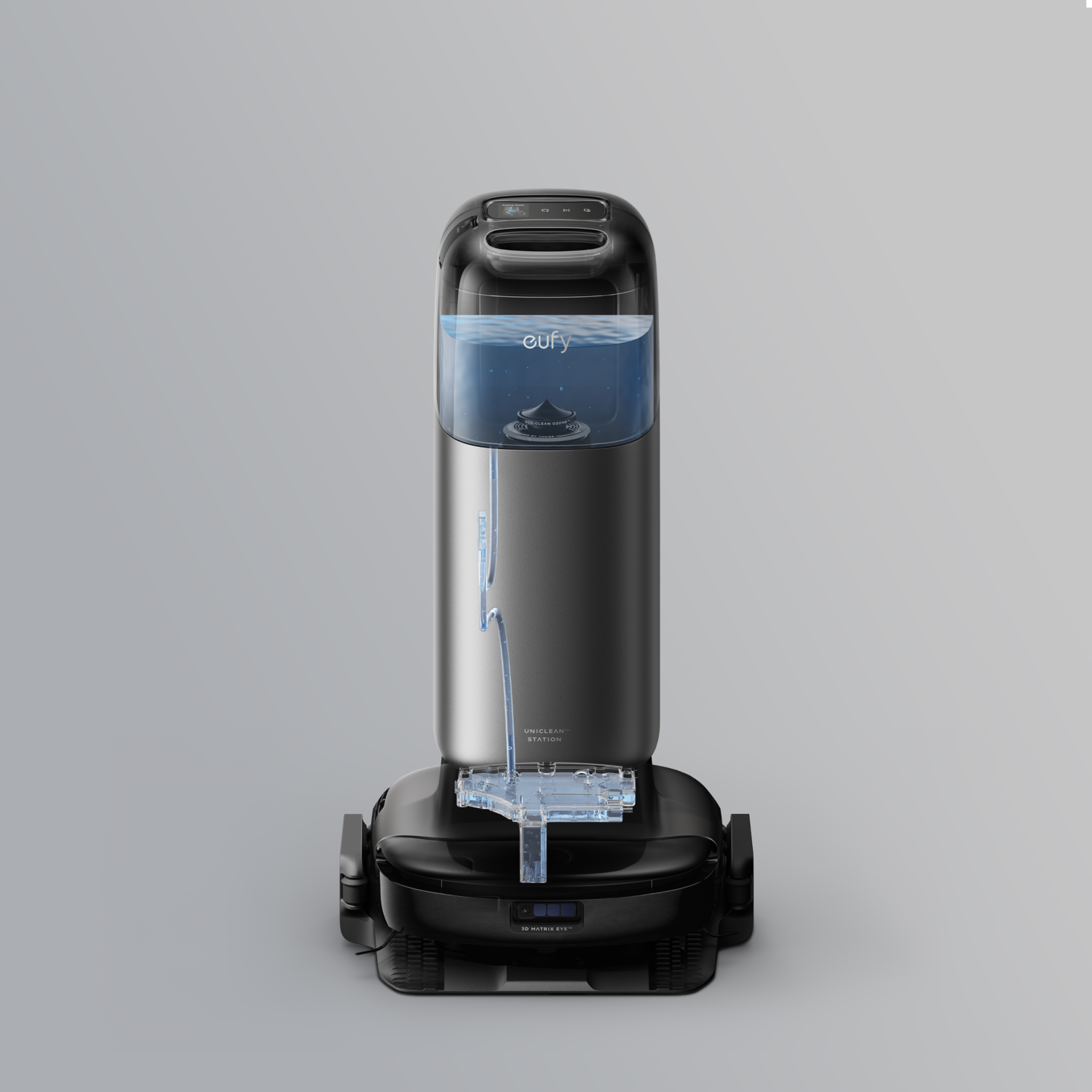 Aspirateur robot eufy noir et argent avec un réservoir d'eau sur le dessus. Sur une surface grise.