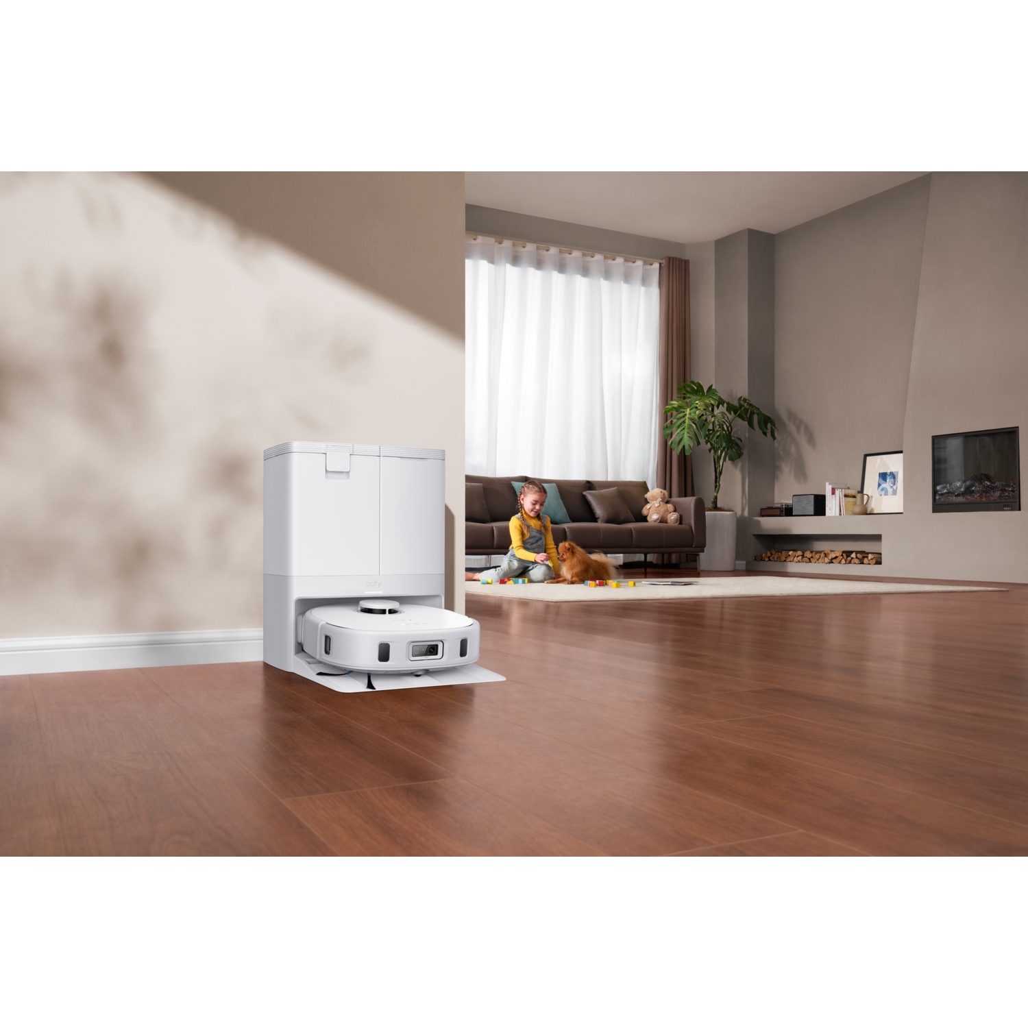 A robot vacuum cleaner in a room, a child and a dog are present in the background.