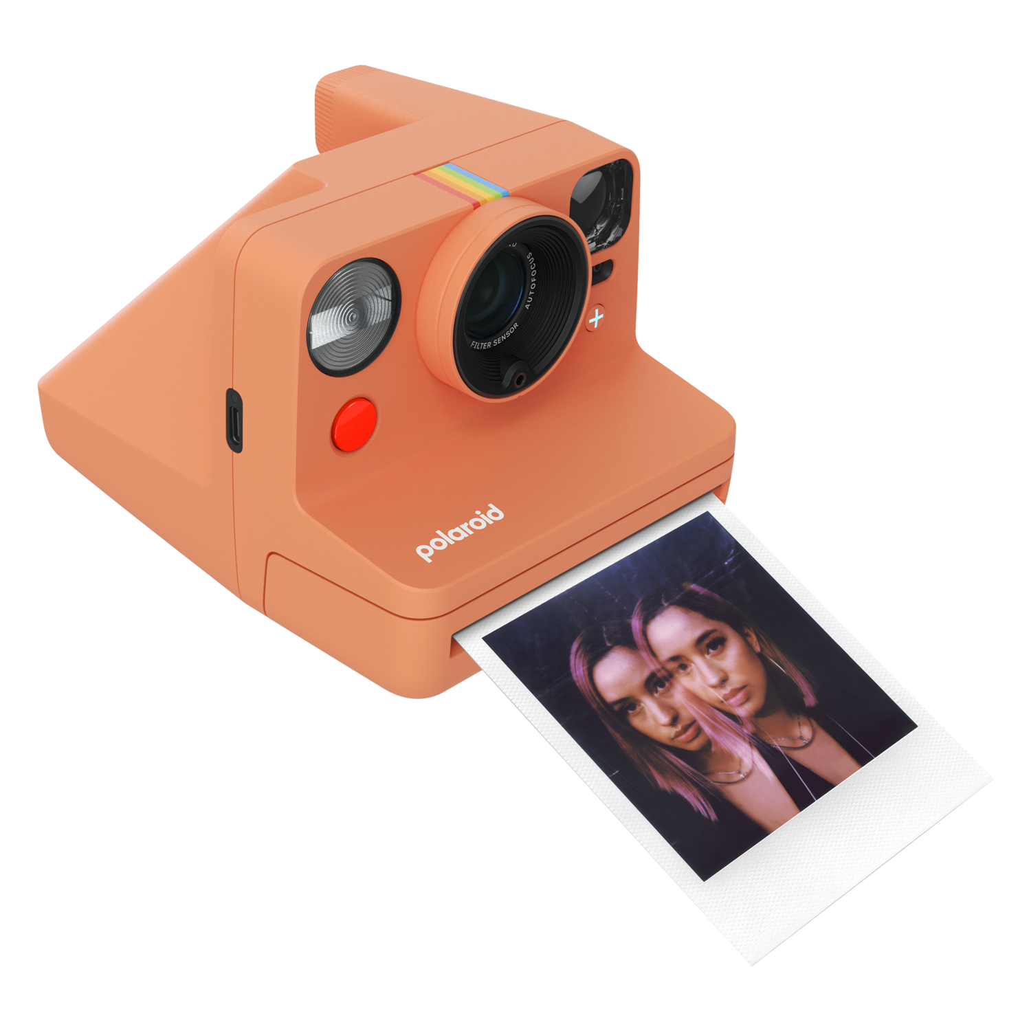 Appareil photo Polaroid orange imprimant une photo de deux femmes. L'appareil photo a une bande arc-en-ciel.