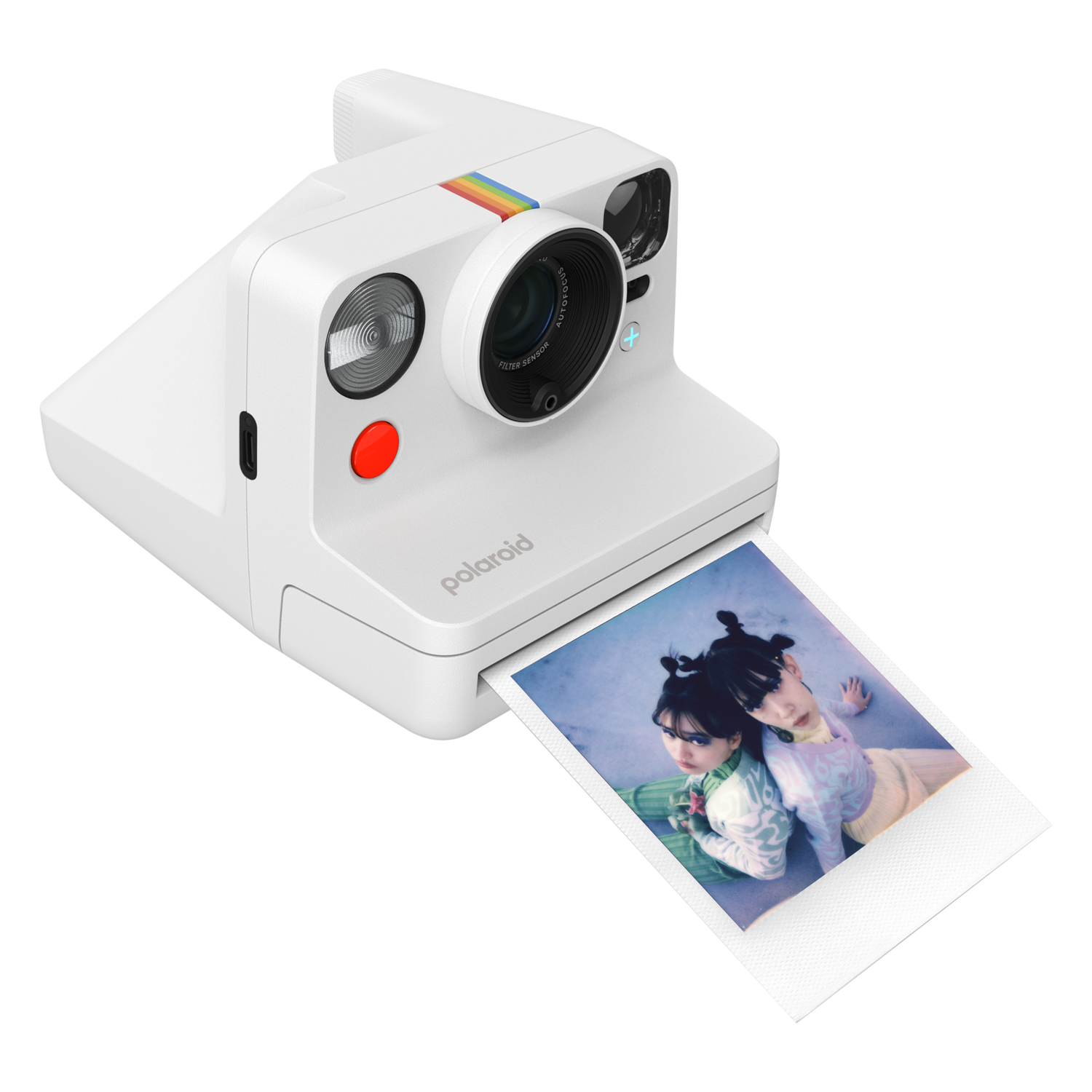 A white Polaroid camera on a black background. Photo is being ejected with two women in the photo.