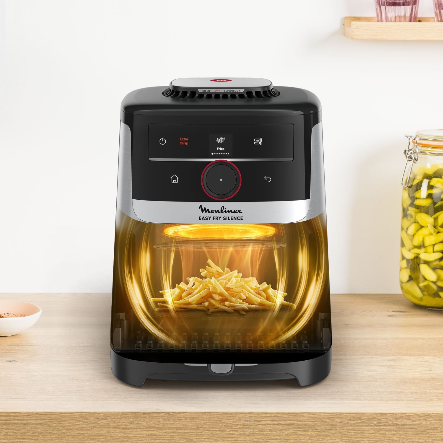 Friteuse à air Moulinex Easy Fry Silence avec frites à l'intérieur, sur bois.
