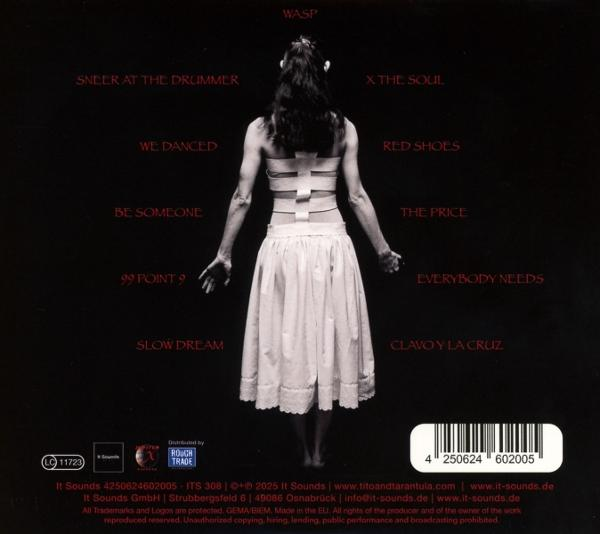 Albumcover eines Künstlers mit langem weißen Kleid, vor dunklem Hintergrund stehend.