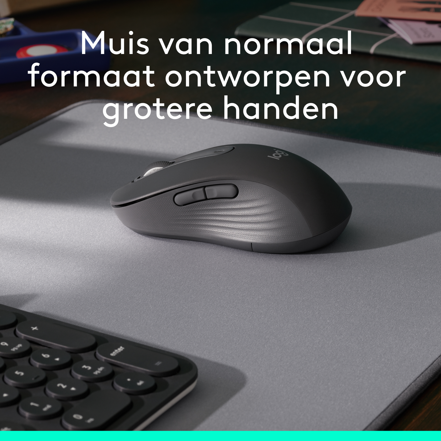 Een grijze muis op een grijze muismat met een toetsenbord in beeld.