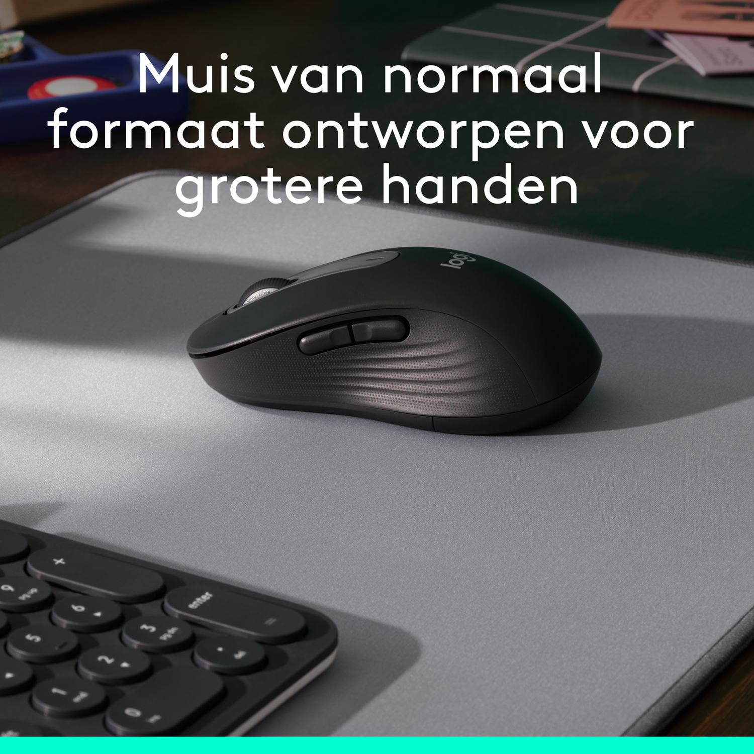A black Logitech mouse on a gray mousepad. A keyboard and desk items are in the background.