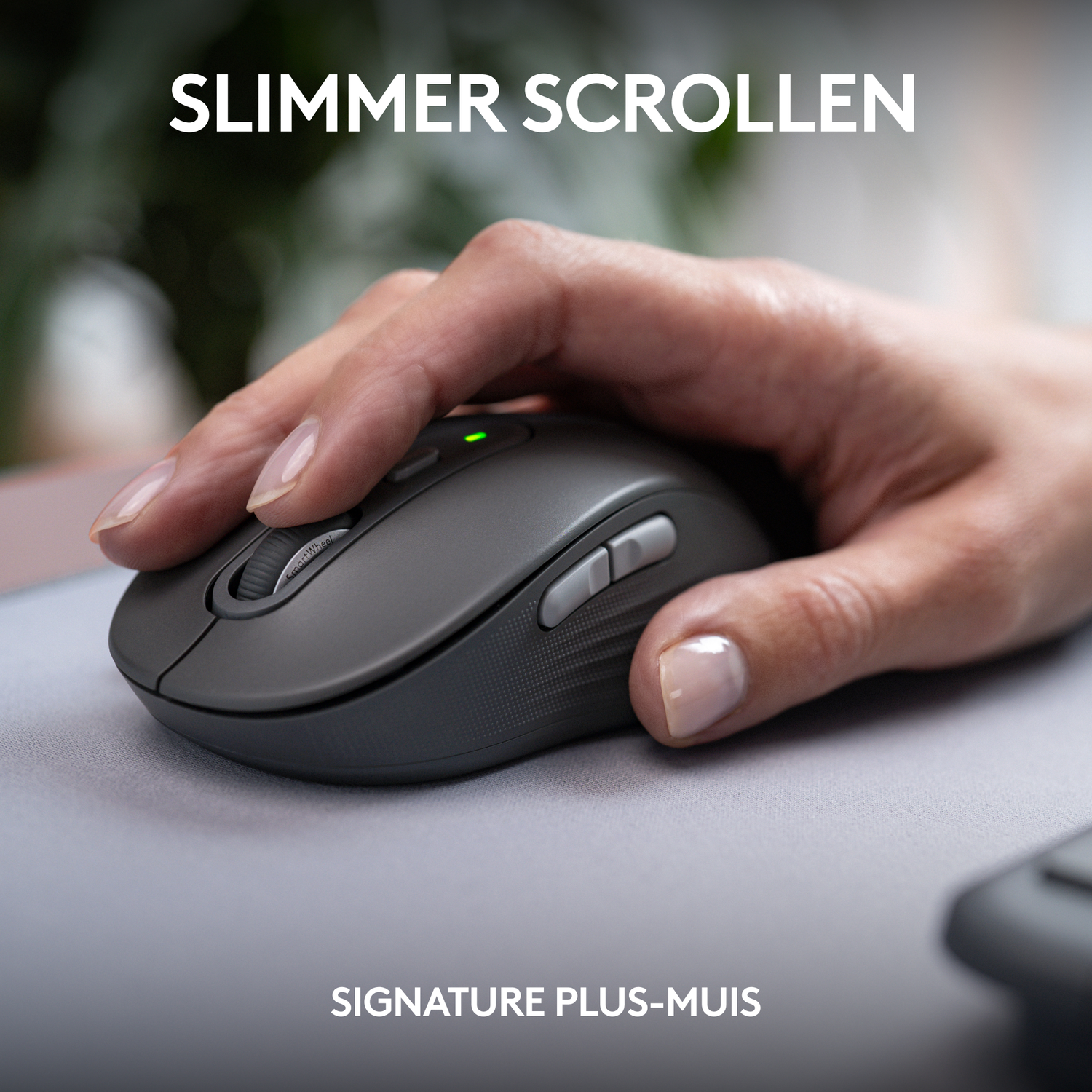 A hand using a dark gray mouse on a mousepad. Text: Slimmer scroll, Signature Plus mouse.